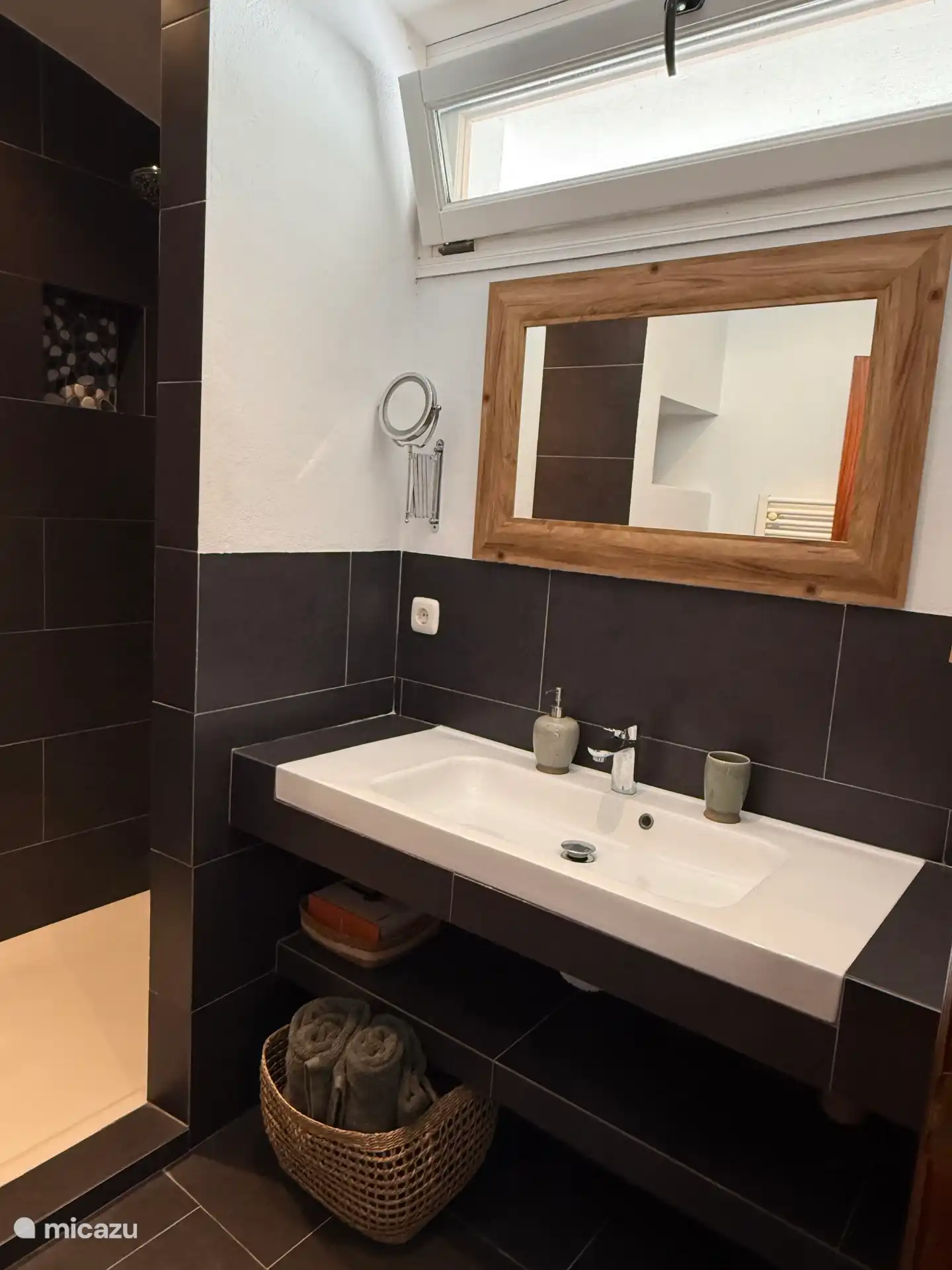 Stijlvolle badkamer met ruime wastafel en luxe inloopdouche.