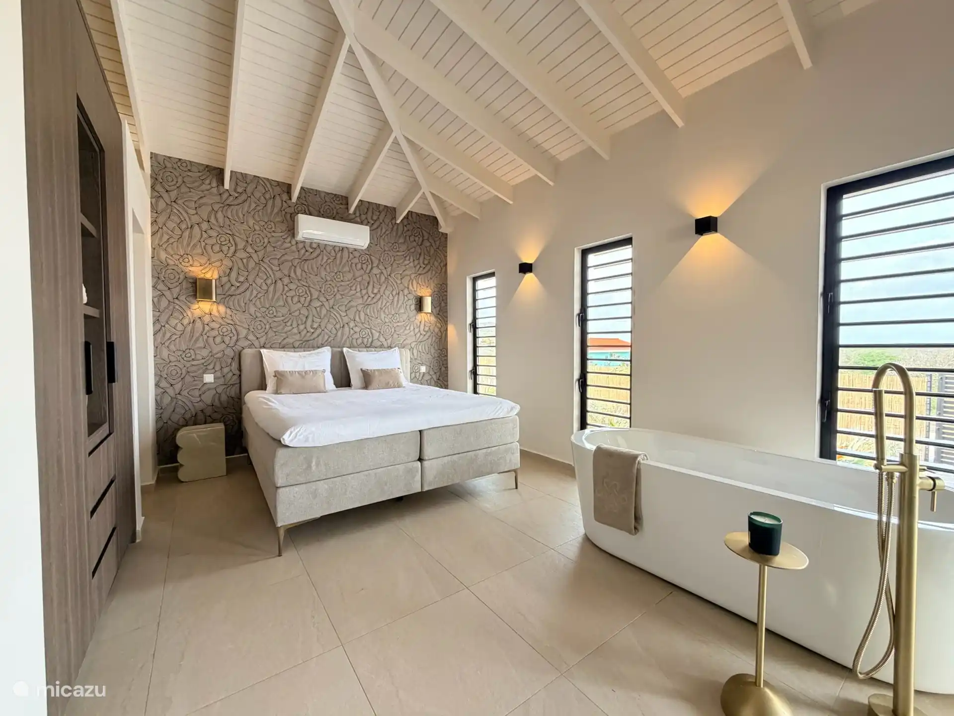Ruime master suite met vrijstaand bad, en-suite badkamer en directe toegang tot de porch.