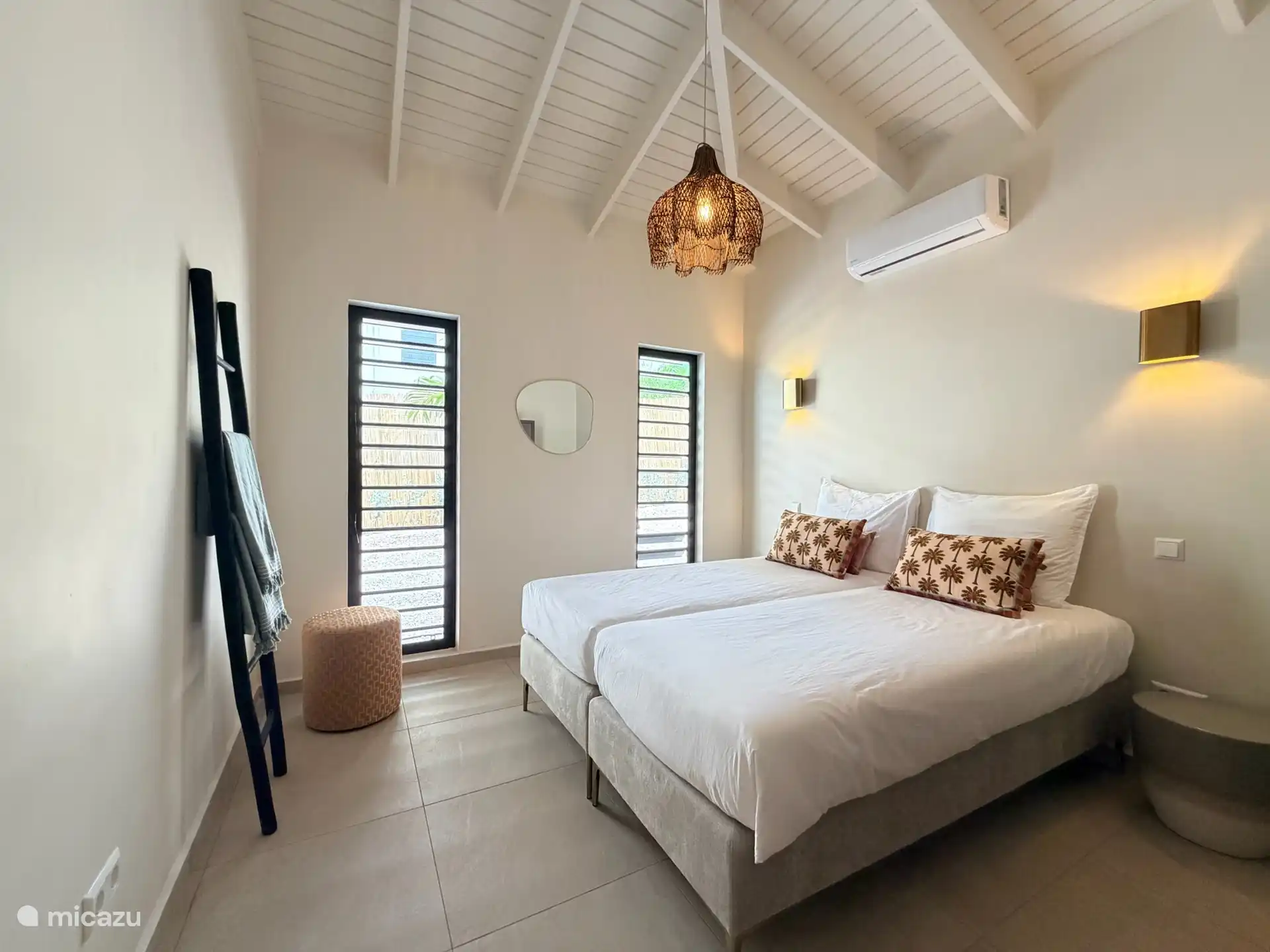 Comfortabele tweede slaapkamer met airconditioning en sfeervolle tropische details.