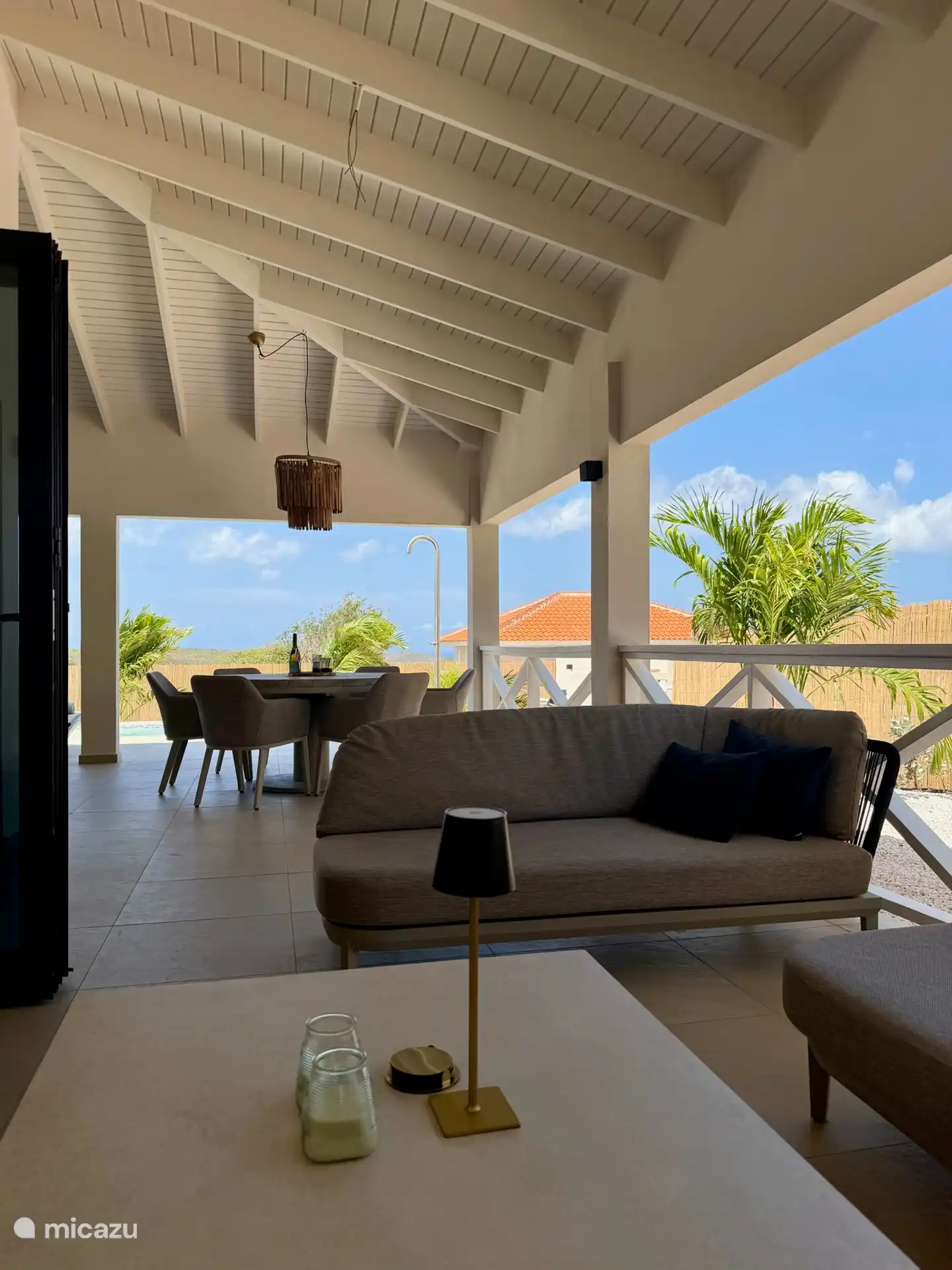 Beschutte loungehoek op de porch – een heerlijke plek voor een rustig moment in de schaduw.