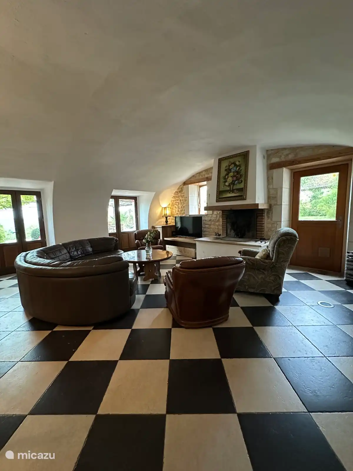 Salon avec meubles confortables, télévision, système audio et cheminée. 