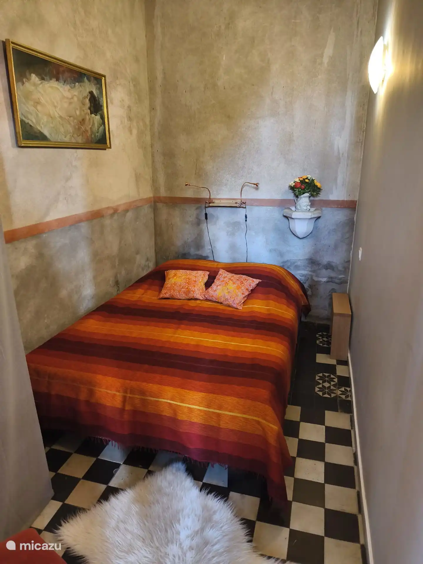 Ein kleines Schlafzimmer öffnet sich zum Hauptraum. Du hast einen Stuhl und einen Stoffschrank, um deine Sachen zu verstauen. Wandmontierte elektrische Heizung.