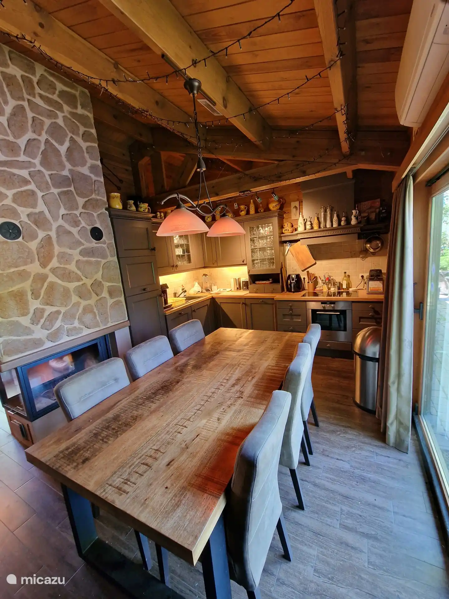 De keuken met eetzaal voor 6 personen. De open haard verwarmt de eethoek en de leefruimte.