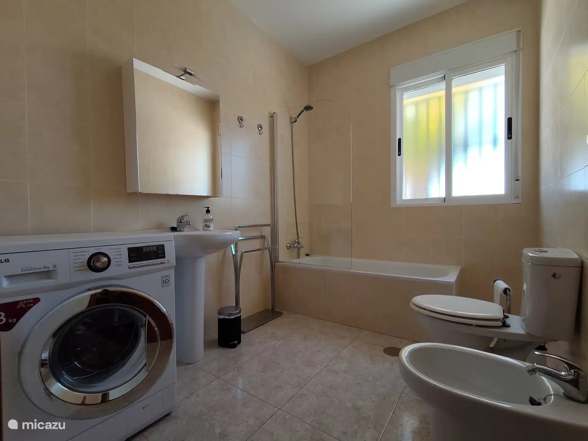 Badezimmer mit Badewanne, Dusche, Toilette, Bidet und Waschmaschine.
