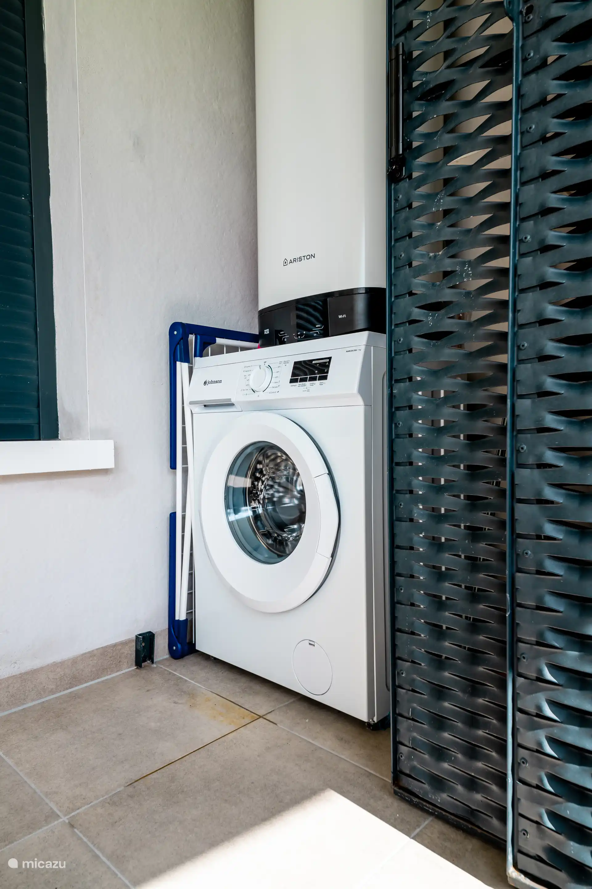 Wasmachine aanwezig met droogrek, strijkplak en strijkijzer.