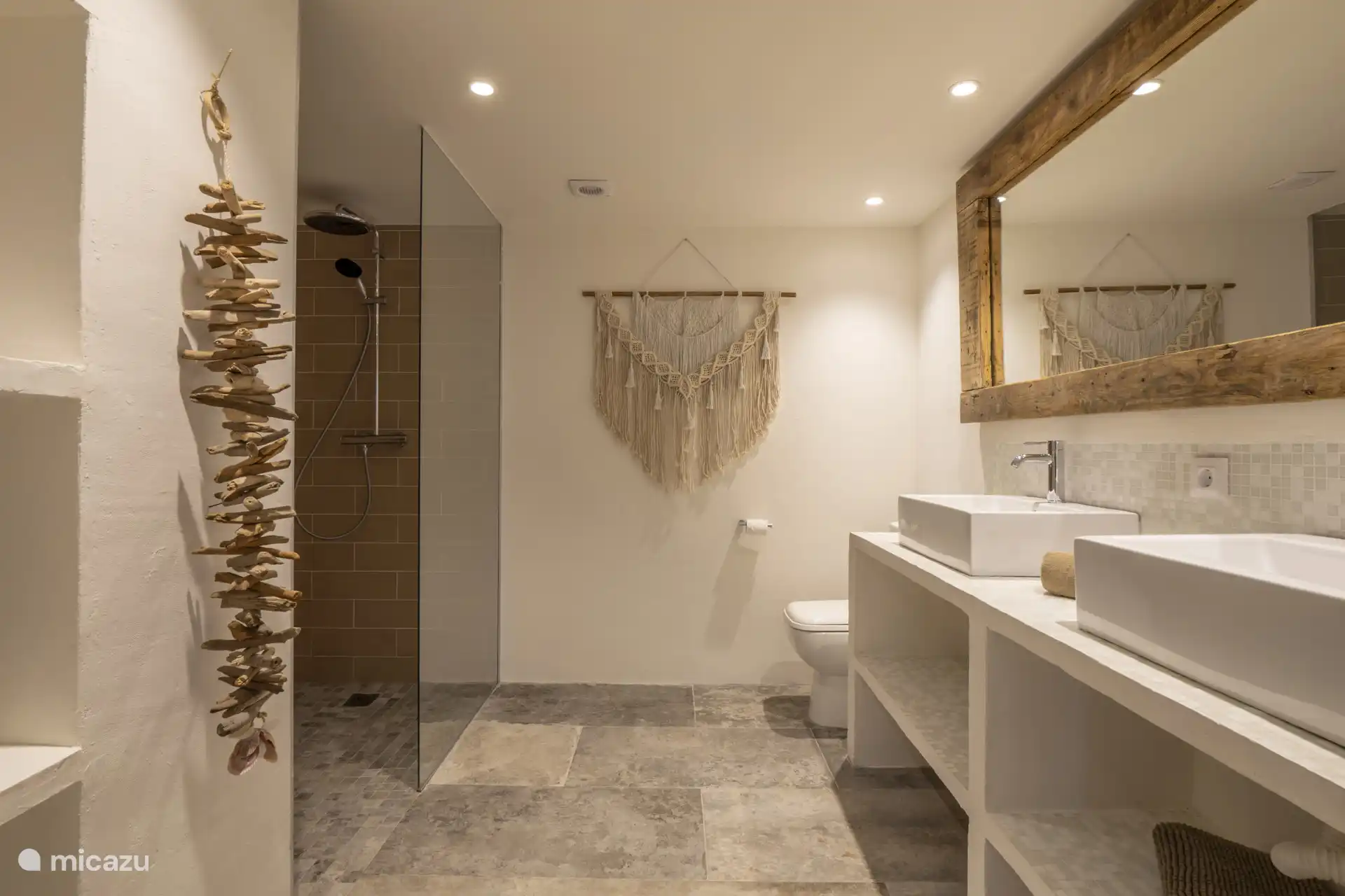 Voorzien van een inloop douche, dubbele wastafel, föhn en een toilet.