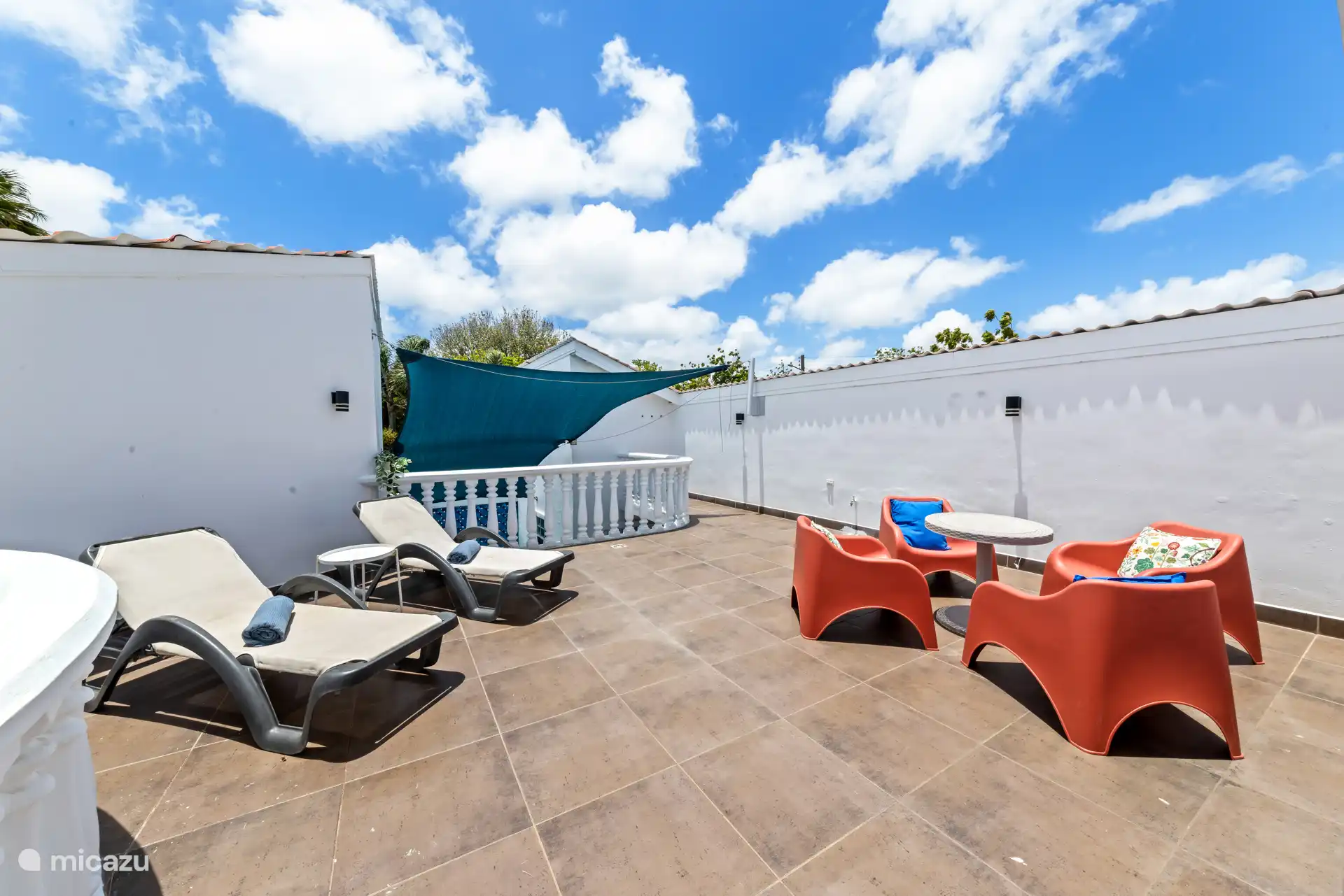 Terrasse ensoleillée avec des transats et des places assises.