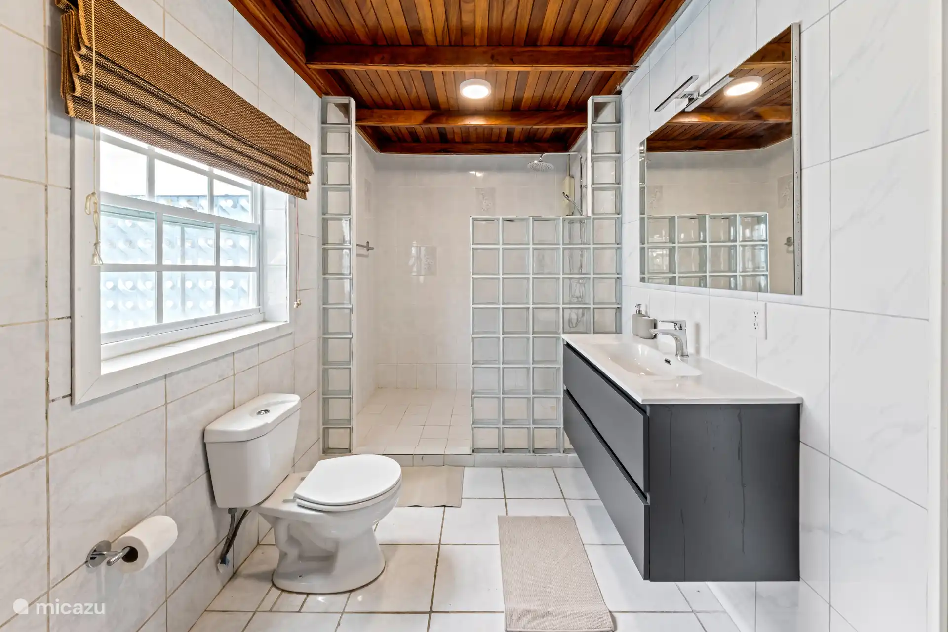 Salle de bain avec lavabo et grande fenêtre.