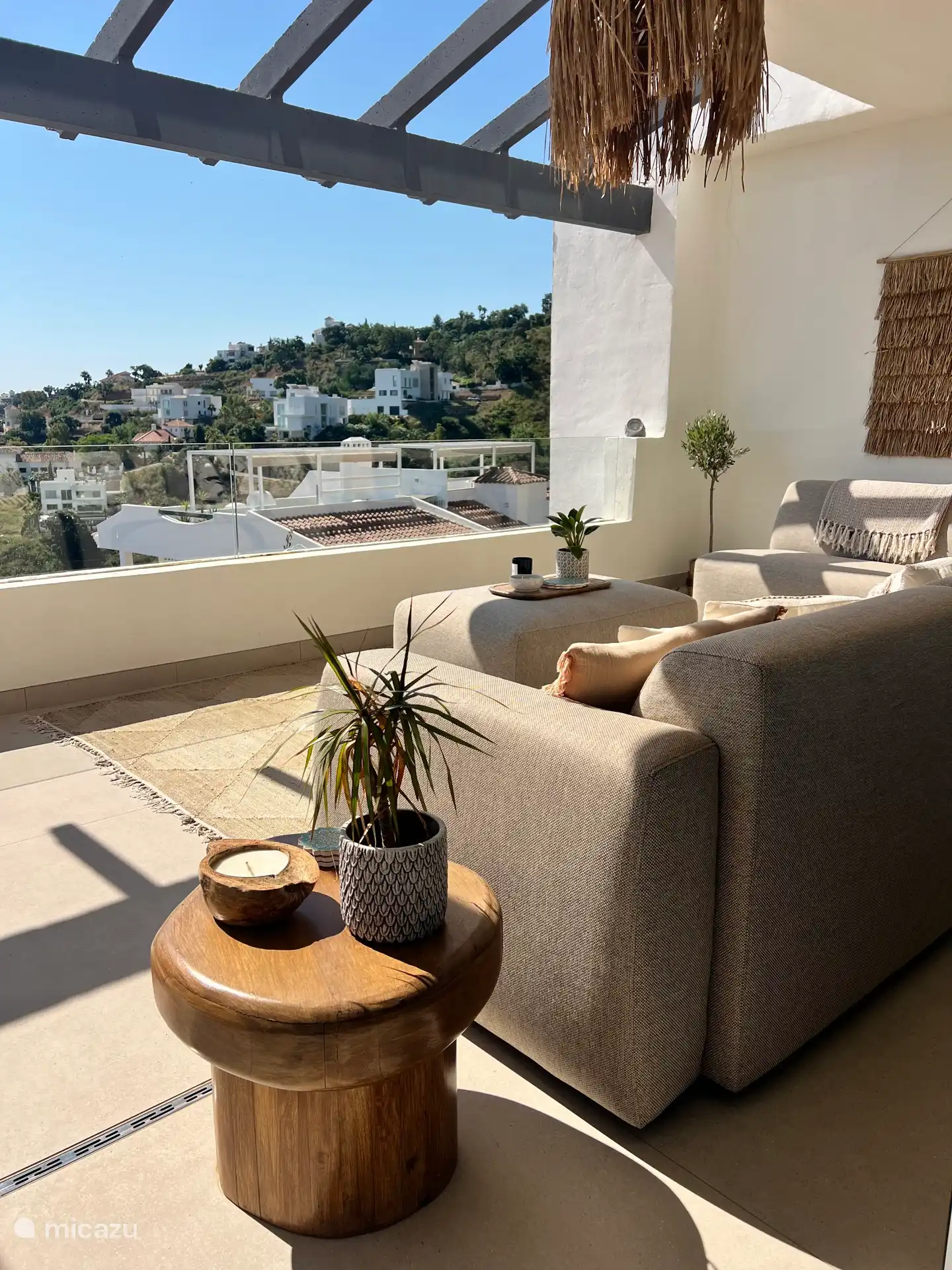 La terrasse accueillante avec un joli canapé extérieur offre non seulement une vue sur la mer, mais aussi sur les maisons du quartier. 