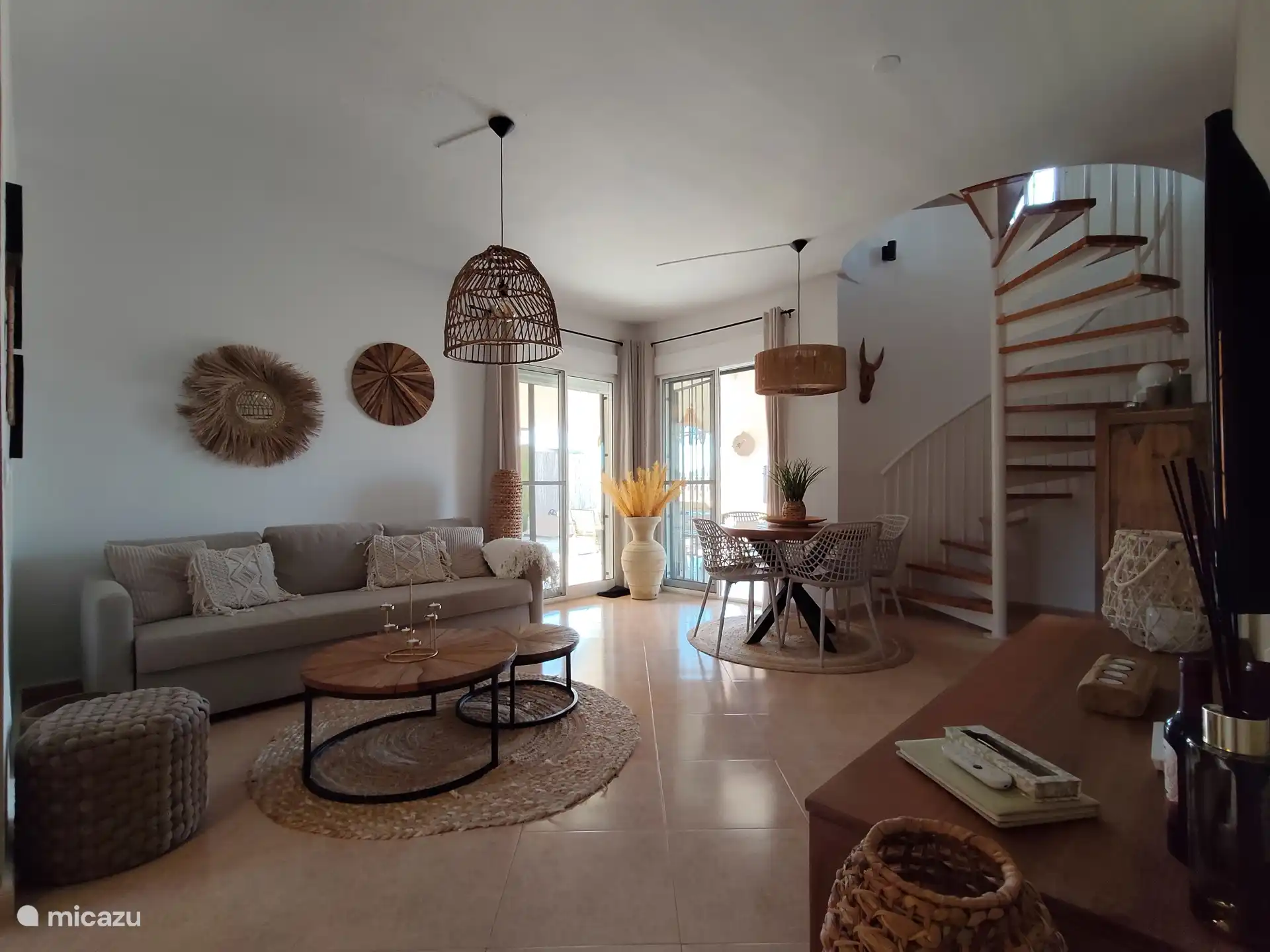 Salón con televisión, mesa de comedor y las escaleras hasta arriba