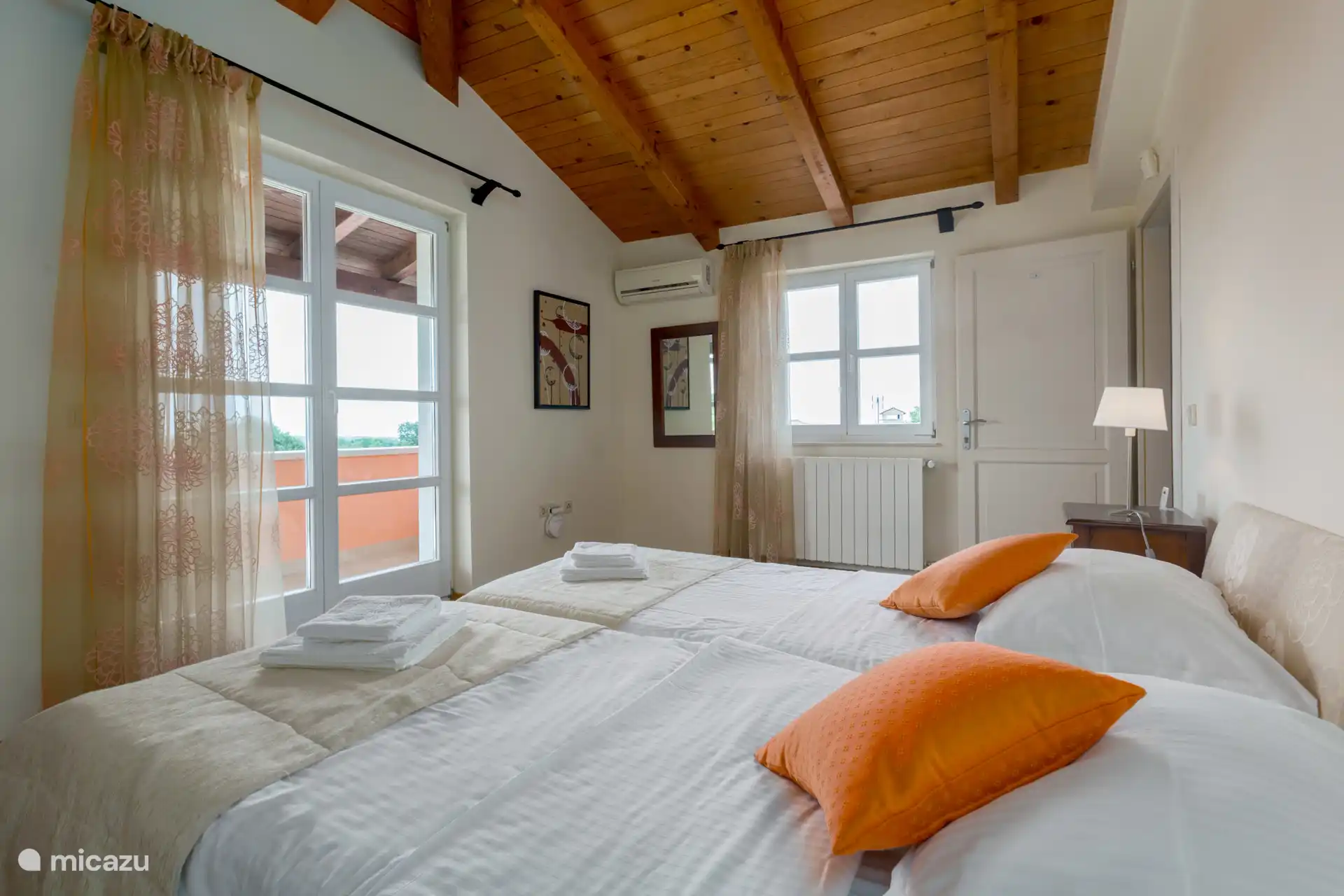 Schlafzimmer mit Klimaanlage und Terrassentüren zur oberen Terrasse