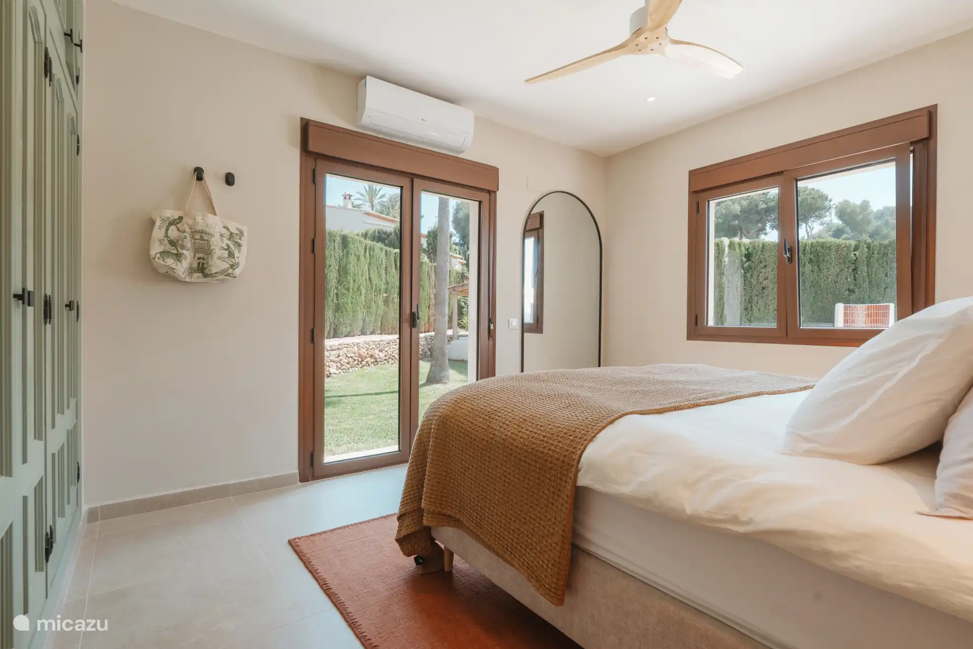 Chambre principale avec portes-patio donnant sur le jardin.