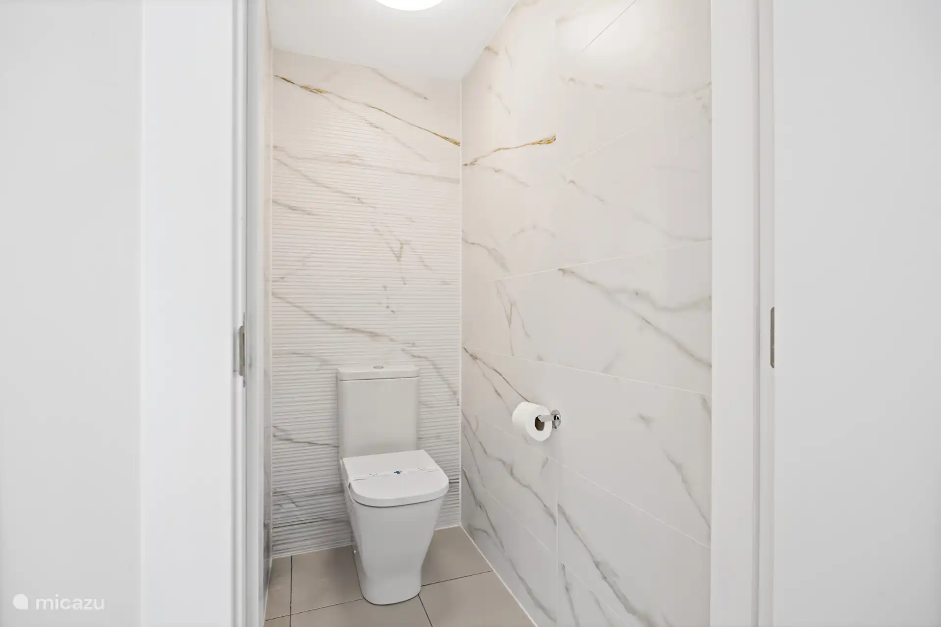 Separaat toilet met marmerlook – strak, schoon en verzorgd tot in de details.
