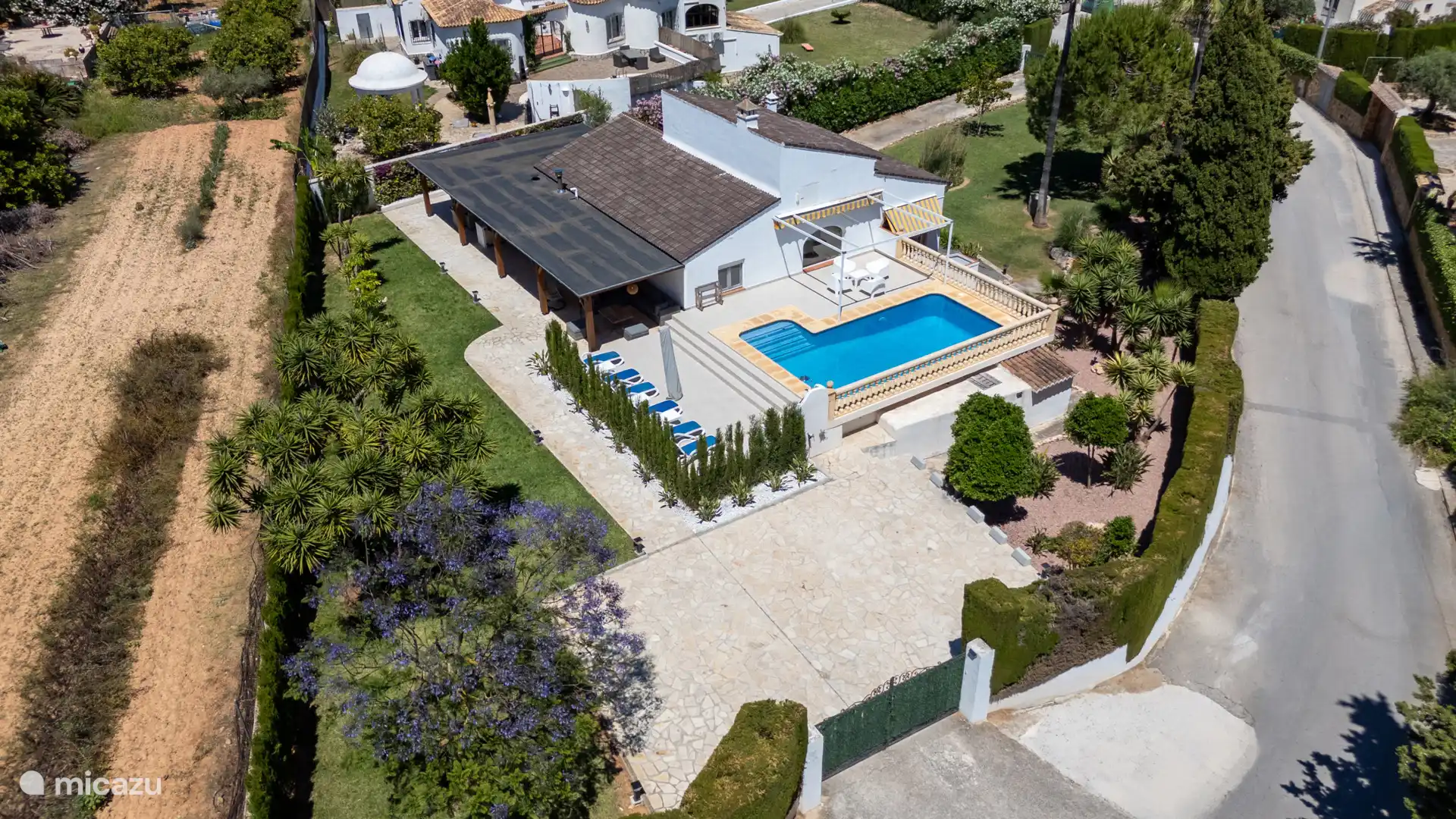 Het zwembad en de ruime buitenruimte van Casa Anfora – ligbedden, mediterrane tuin en volop privacy. Hier wil je de hele dag buiten zijn.