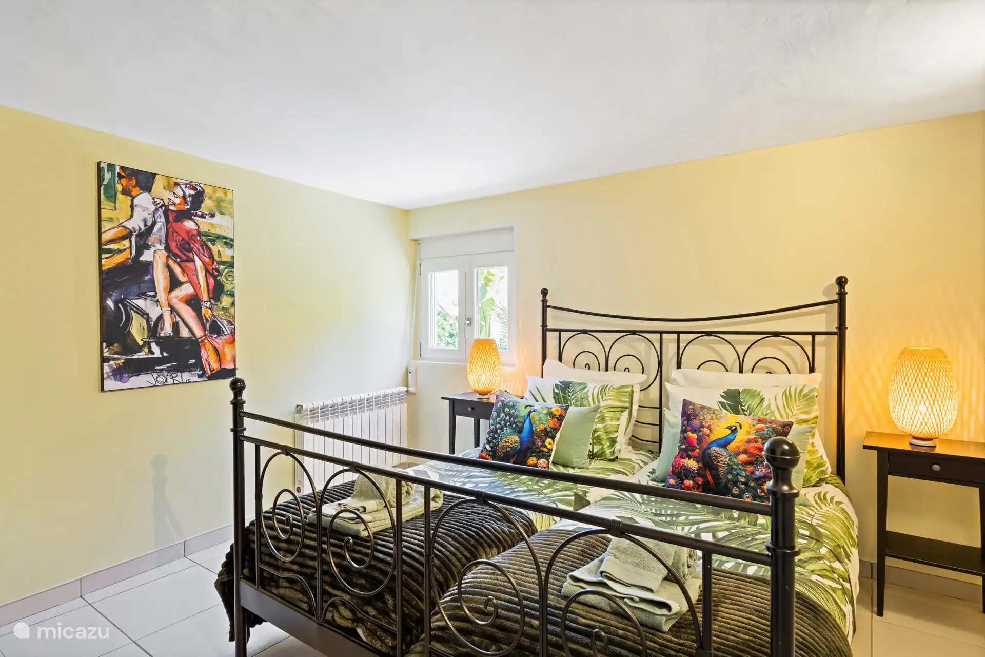 Slaapkamer vol kleur en karakter – vrolijke details, sfeervolle lampen en een comfortabel bed. Hier word je elke ochtend blij van wakker.