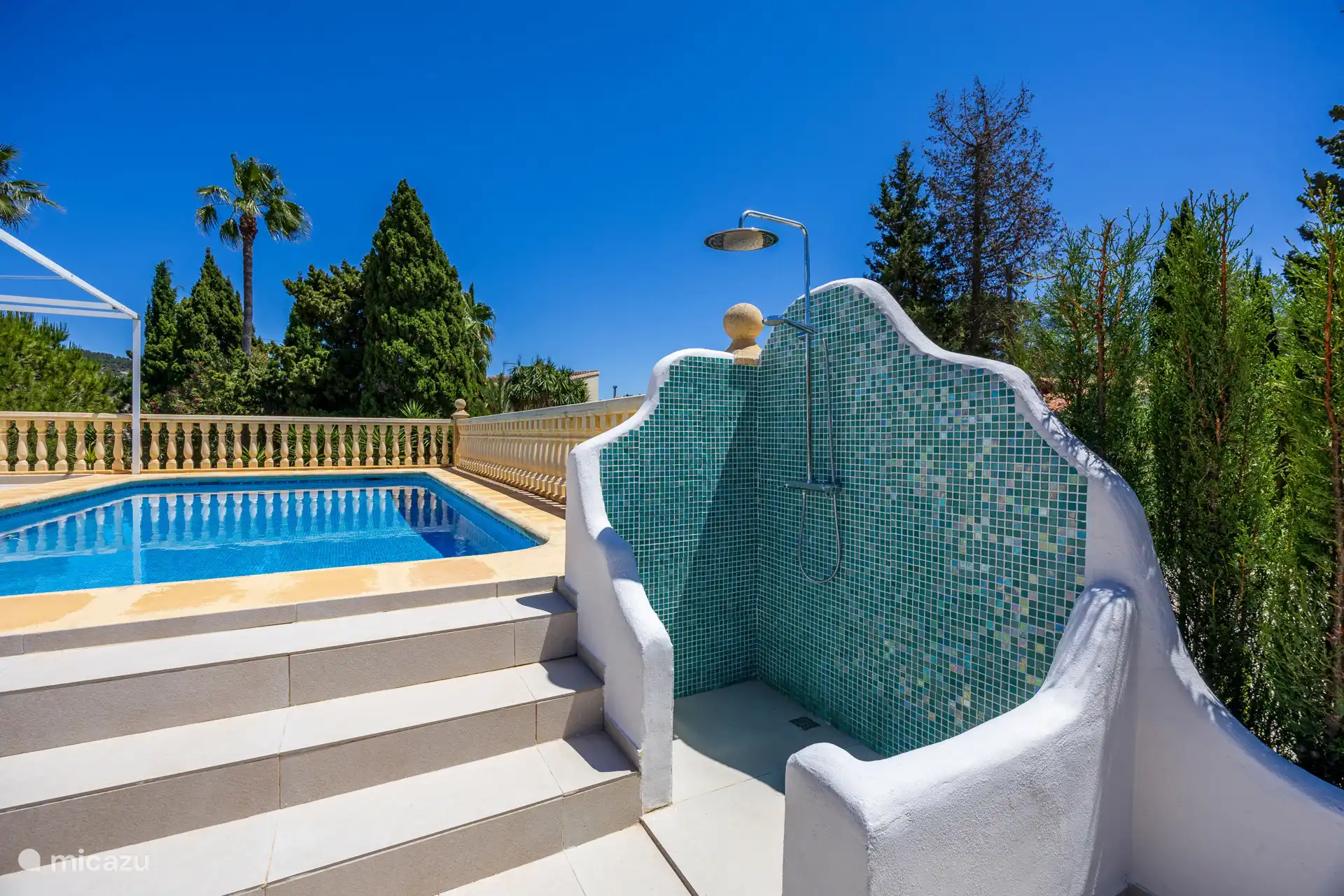 Afspoelen onder de buitendouche met uitzicht op het strakblauwe zwembad – kleine luxe, groot gevoel. De Costa Blanca op zijn best.