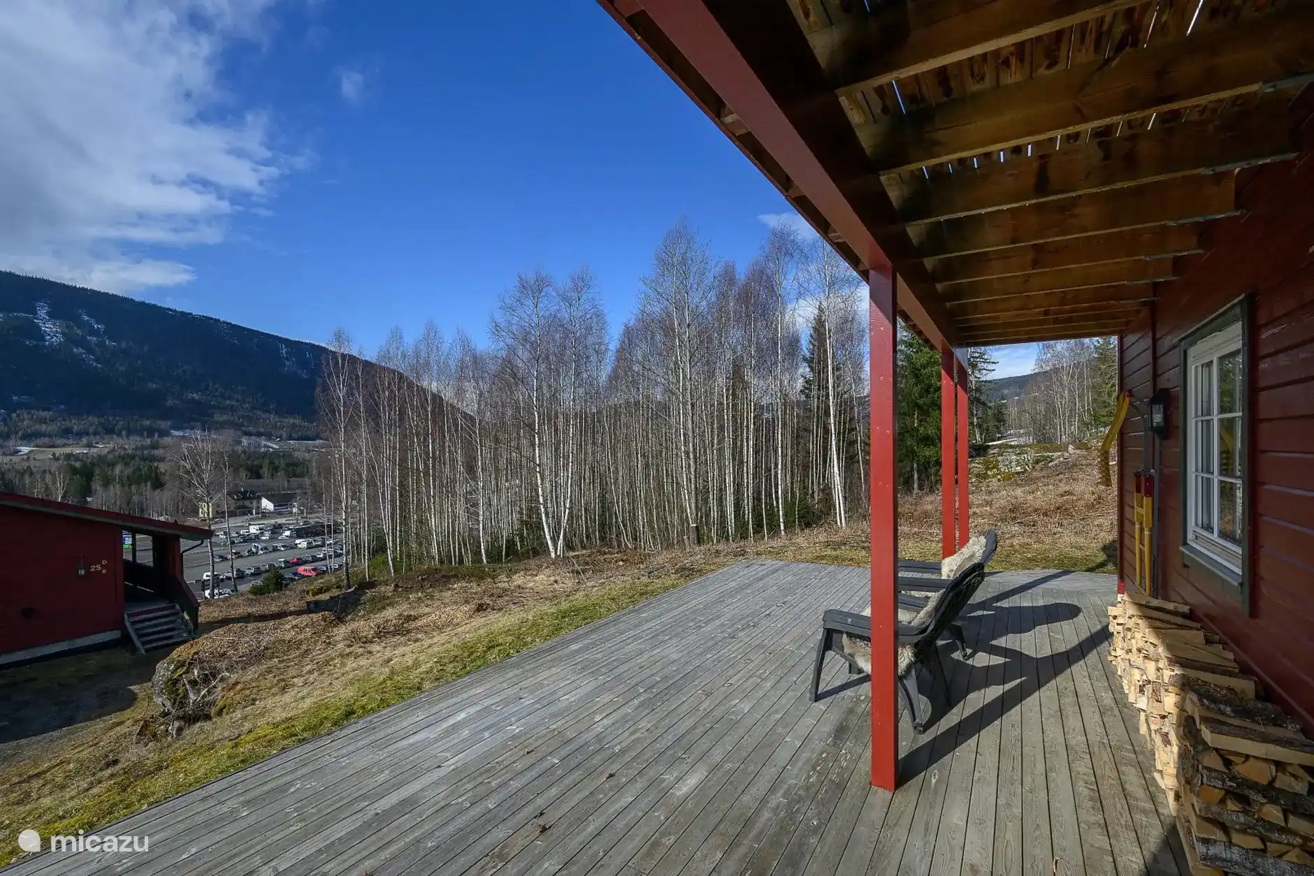 View from the sunny spacious terrace. Fakkelman is visible. On the right is the ski slope and at the bottom the valley station with parking.