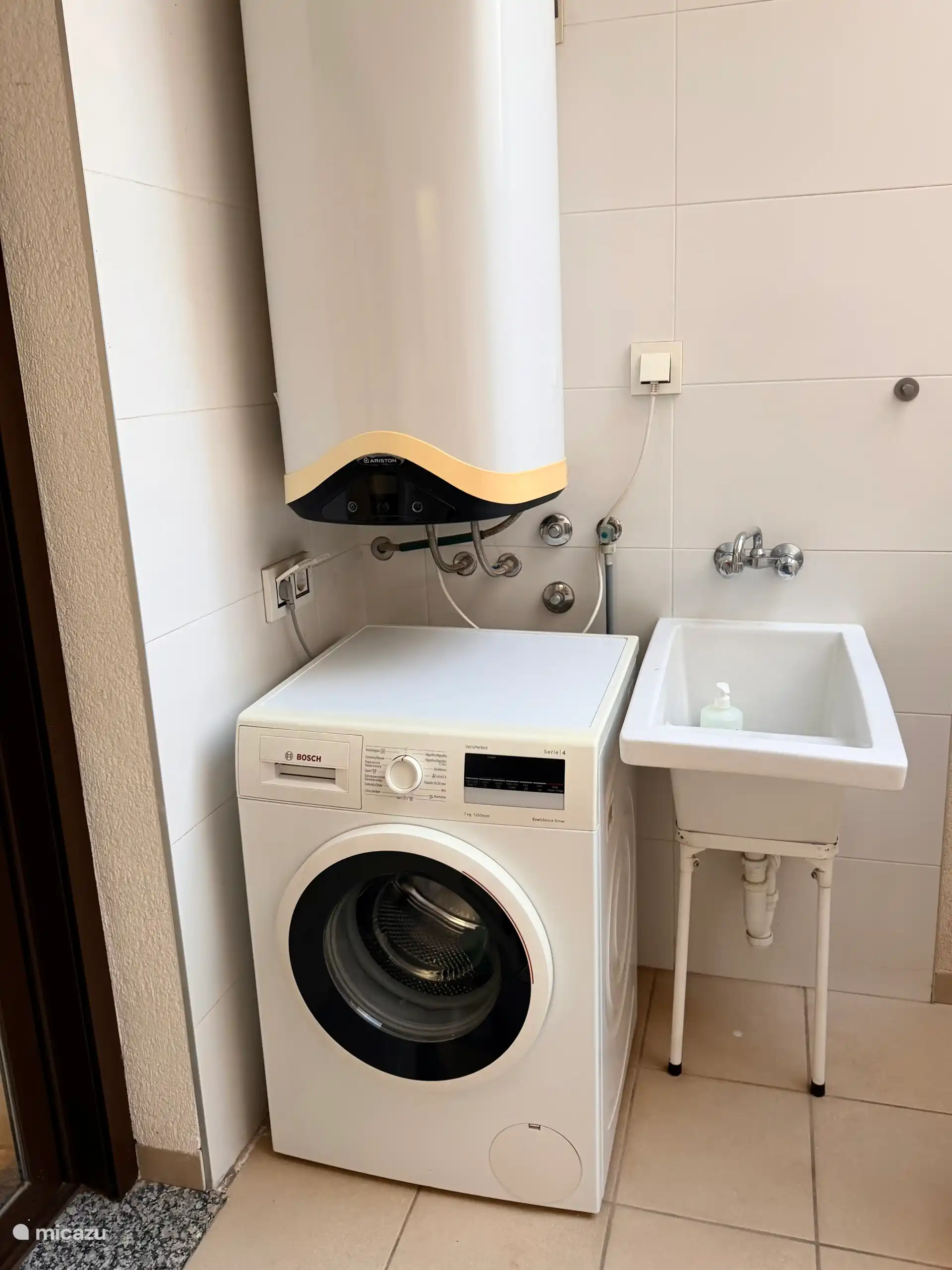 Overdekt gedeelte van de patio met wasmachine en gootsteen