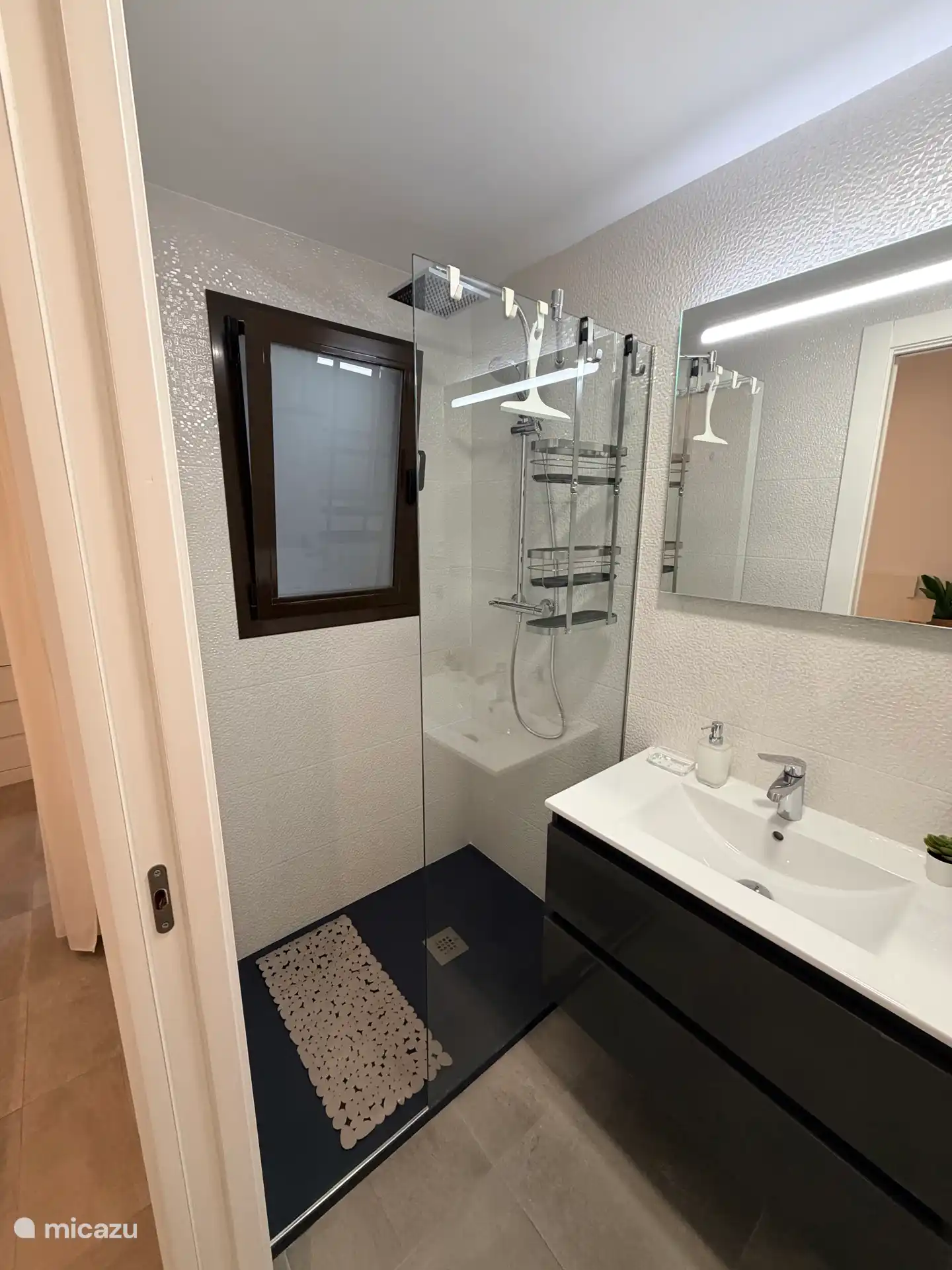 Badkamer grenzend aan slaapkamer 2 met douche, badmeubel en toilet