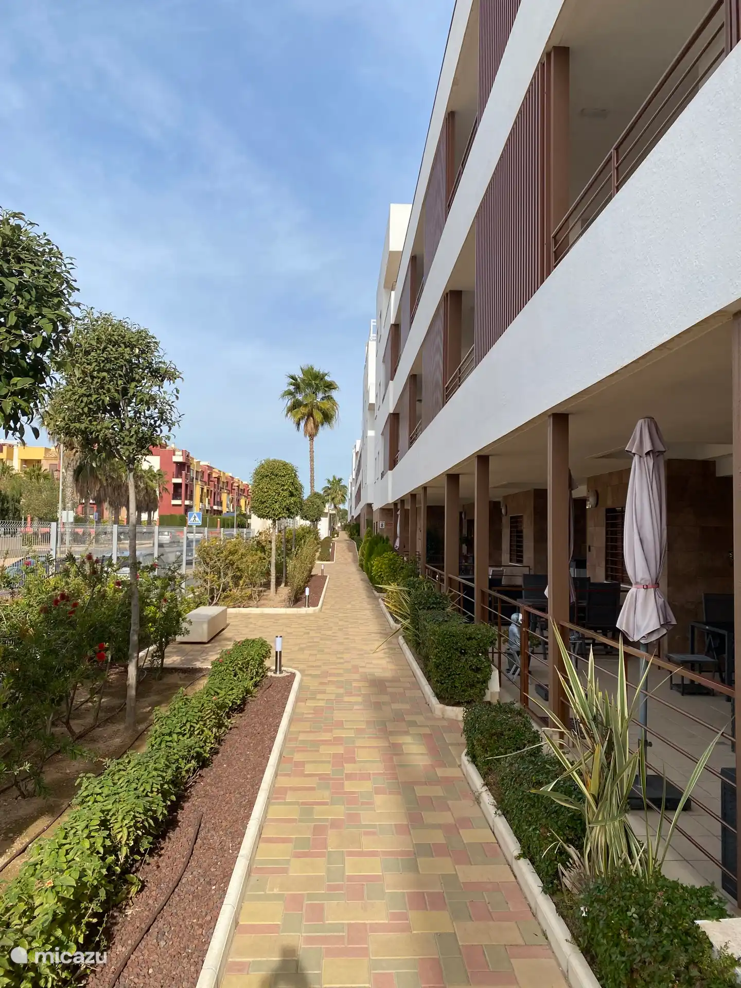 The complex is closed and one enters through the gate, which opens with a code. This is the path towards the apartment. With a terrace at the front.