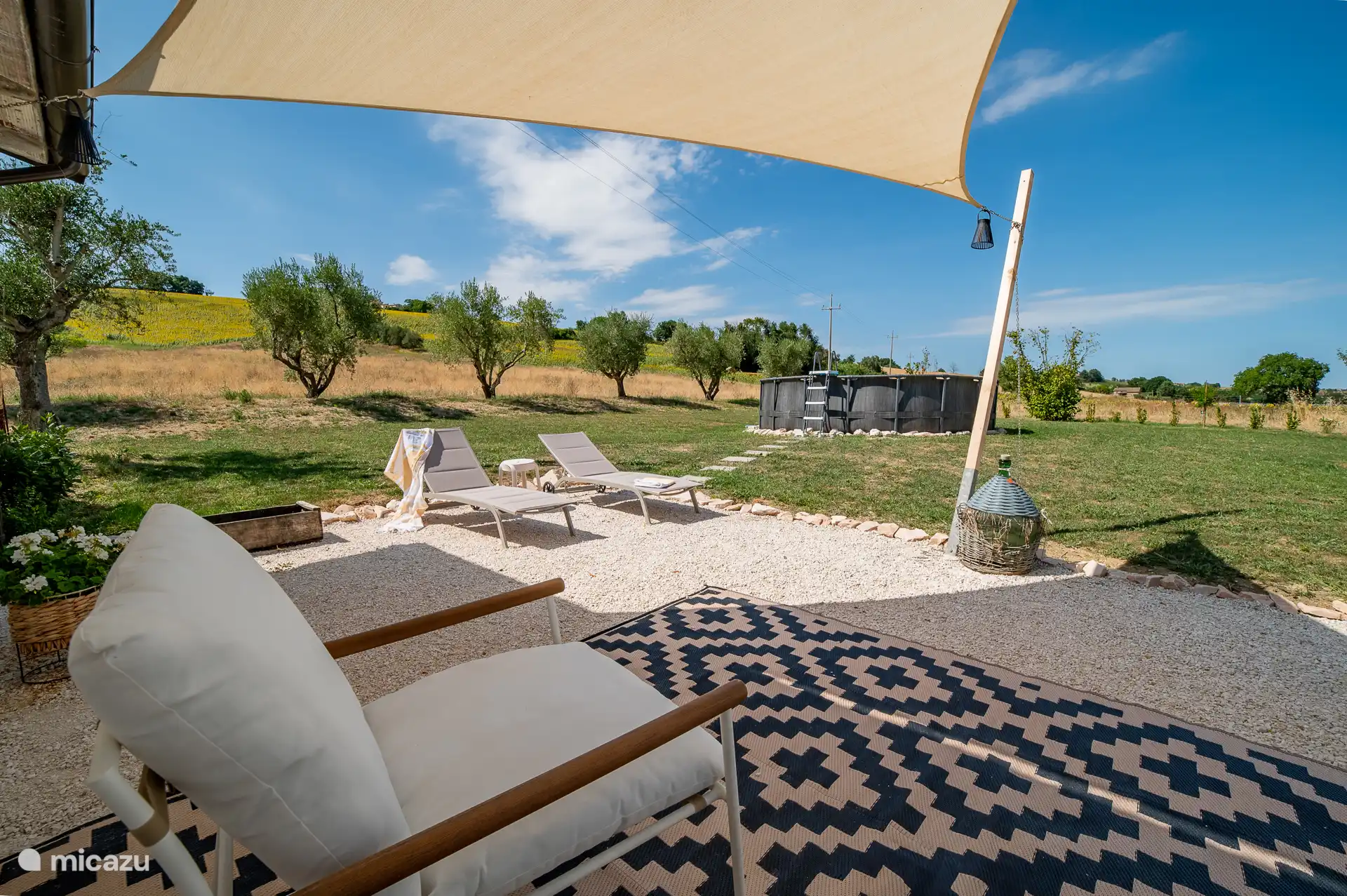 Schaduwterras met comfi loungestoelen en ligbedjes