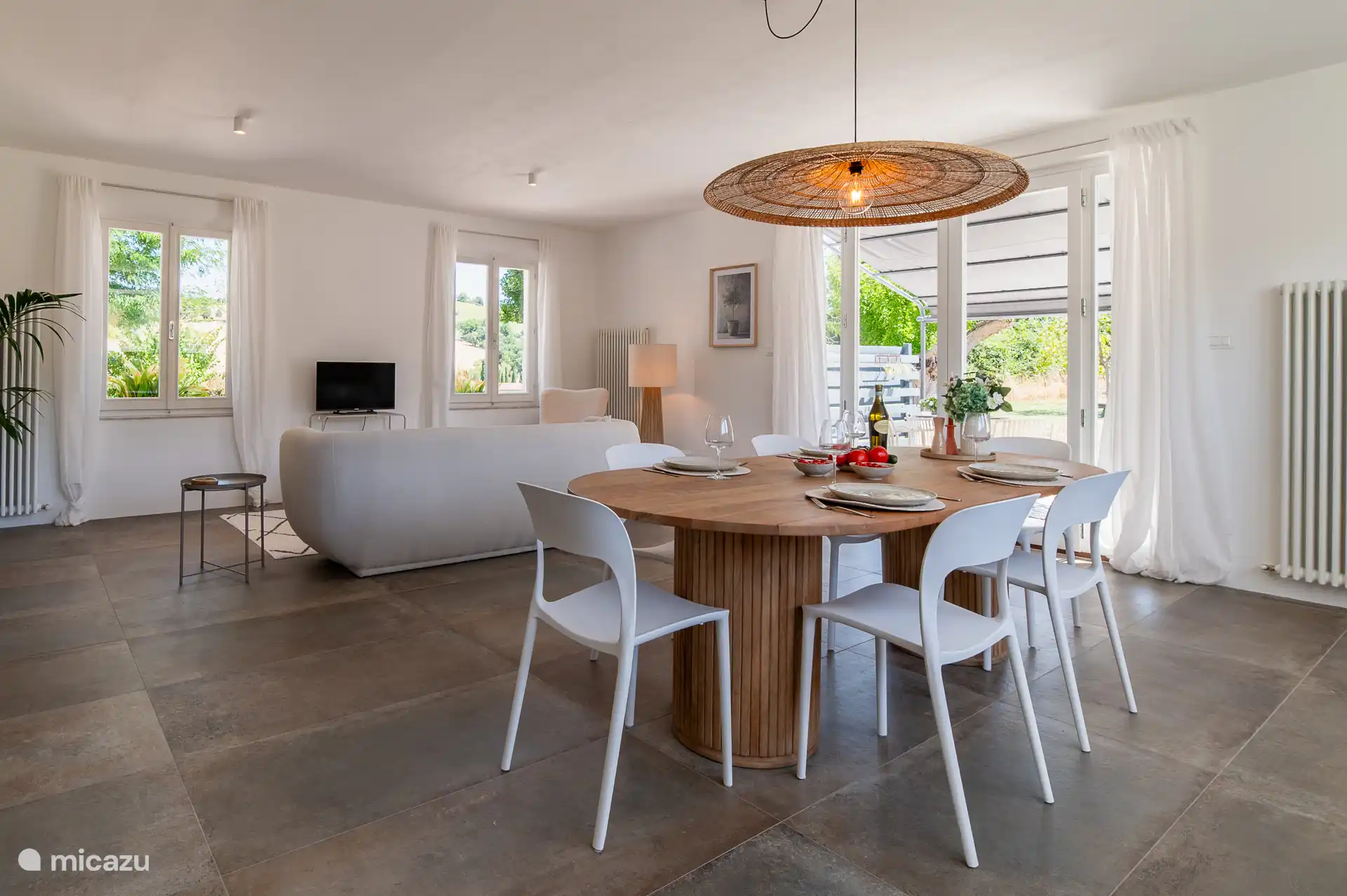 De bijzondere eettafel van mangohout, meet maar liefst 2,5m, erbij staan leuke witte designstoeltjes.