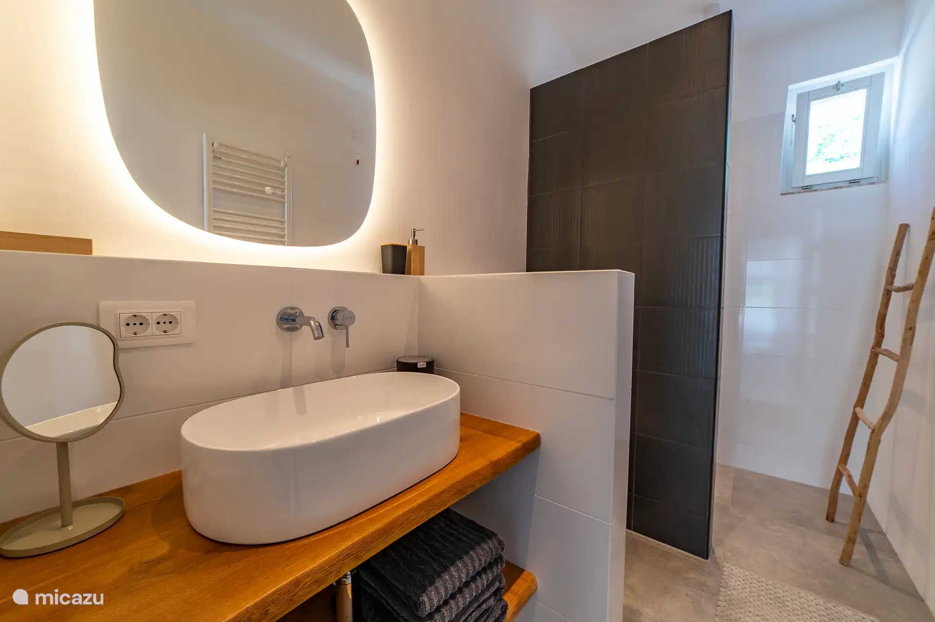 Ook design in de badkamer met hele bijzondere zwarte tegels op de wand.
