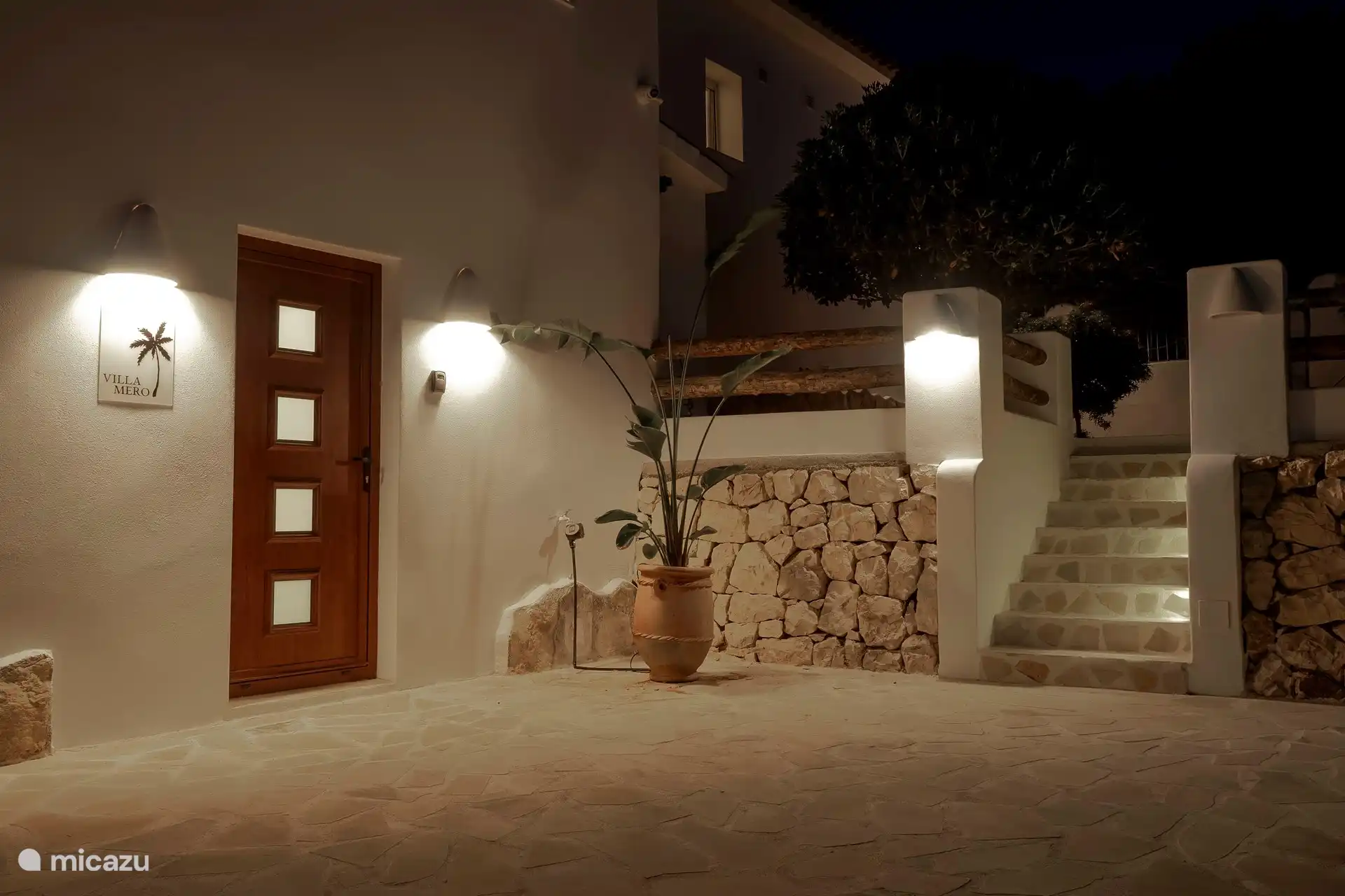 Entrada Villa Mero con portón y aparcamiento vallado para 3 coches.