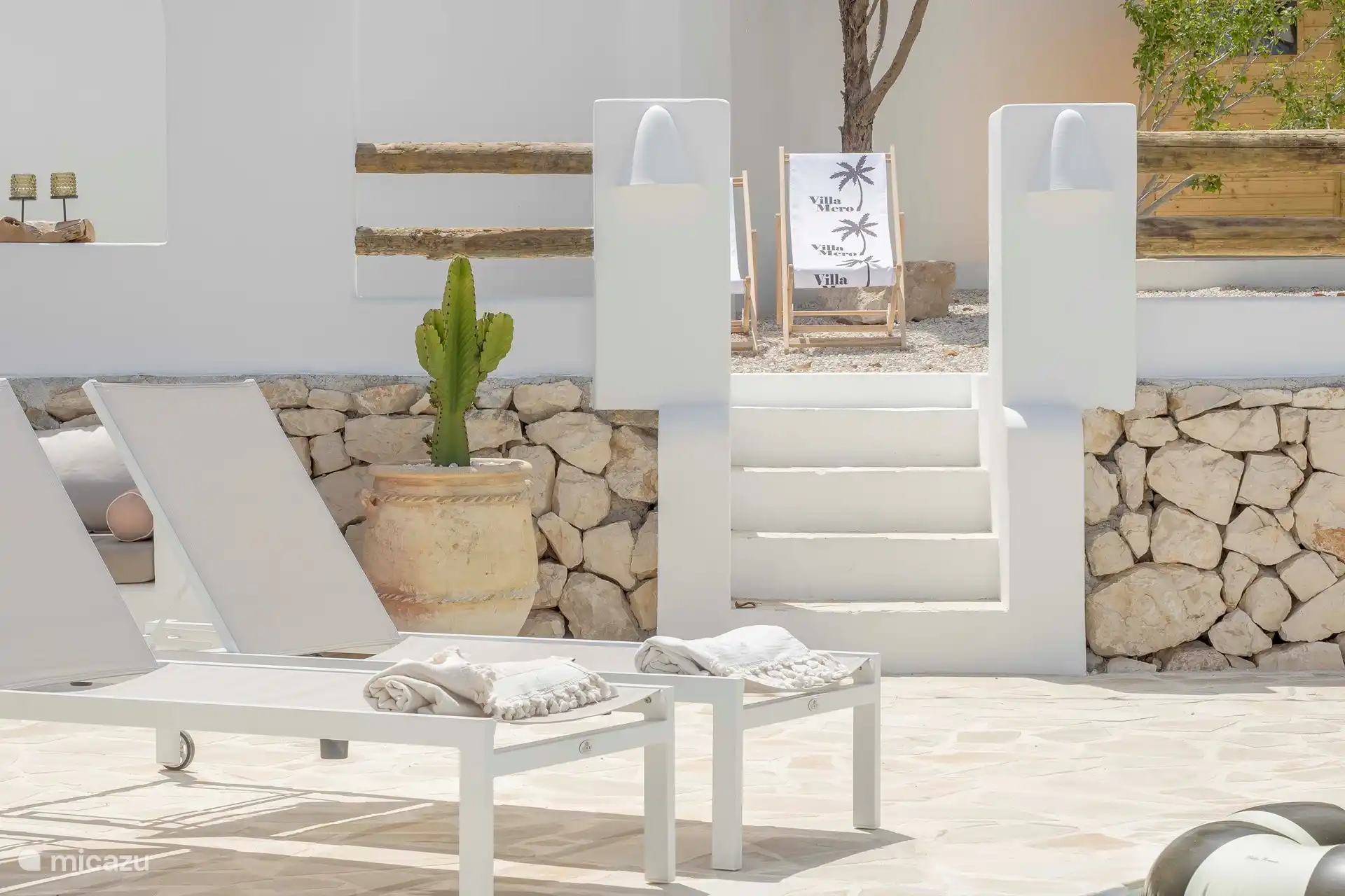 Terraza de Villa Mero con 10 tumbonas y 3 sombrillas de paja, varias. zonas de estar, baño exterior y ducha