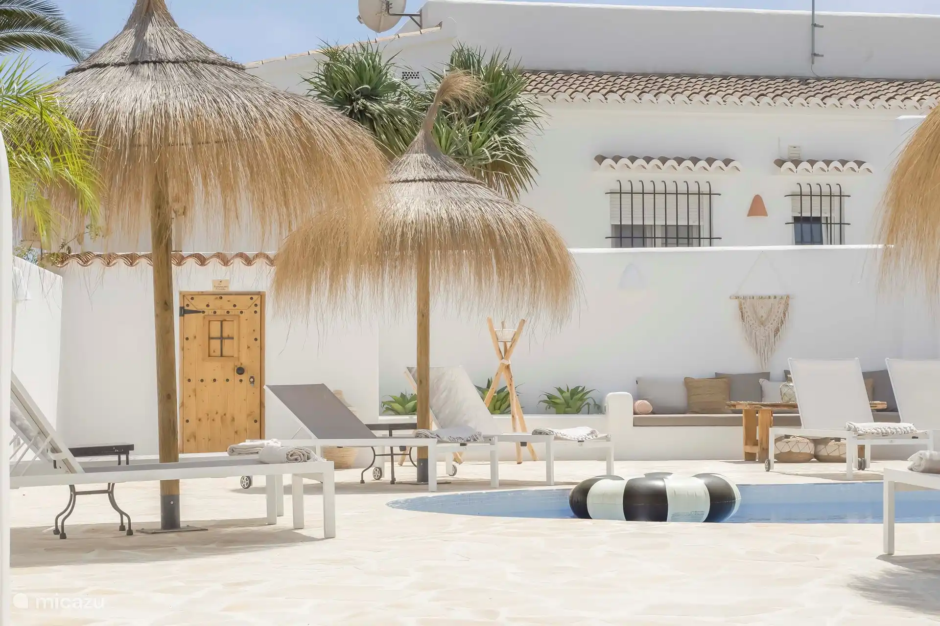 Piscina Villa Mero con 10 tumbonas, 3 sombrillas con techo de paja, varias zonas de estar, aseo y ducha exterior