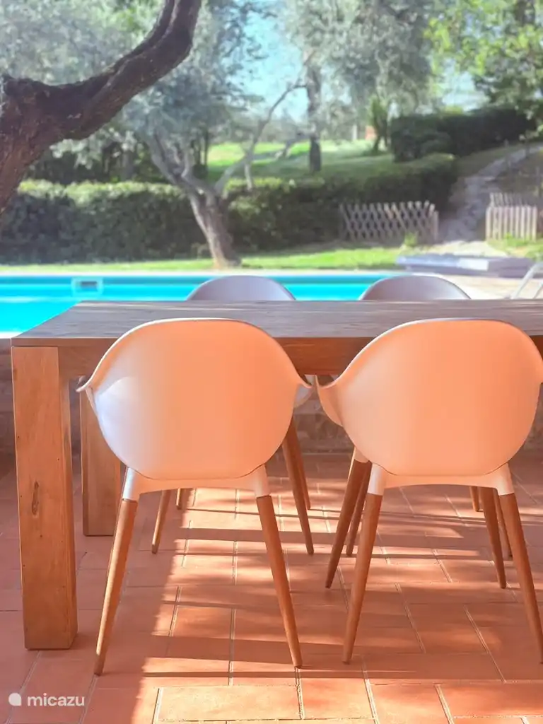 Een van de zitplaatsen in het poolhouse met zicht op het zwembad