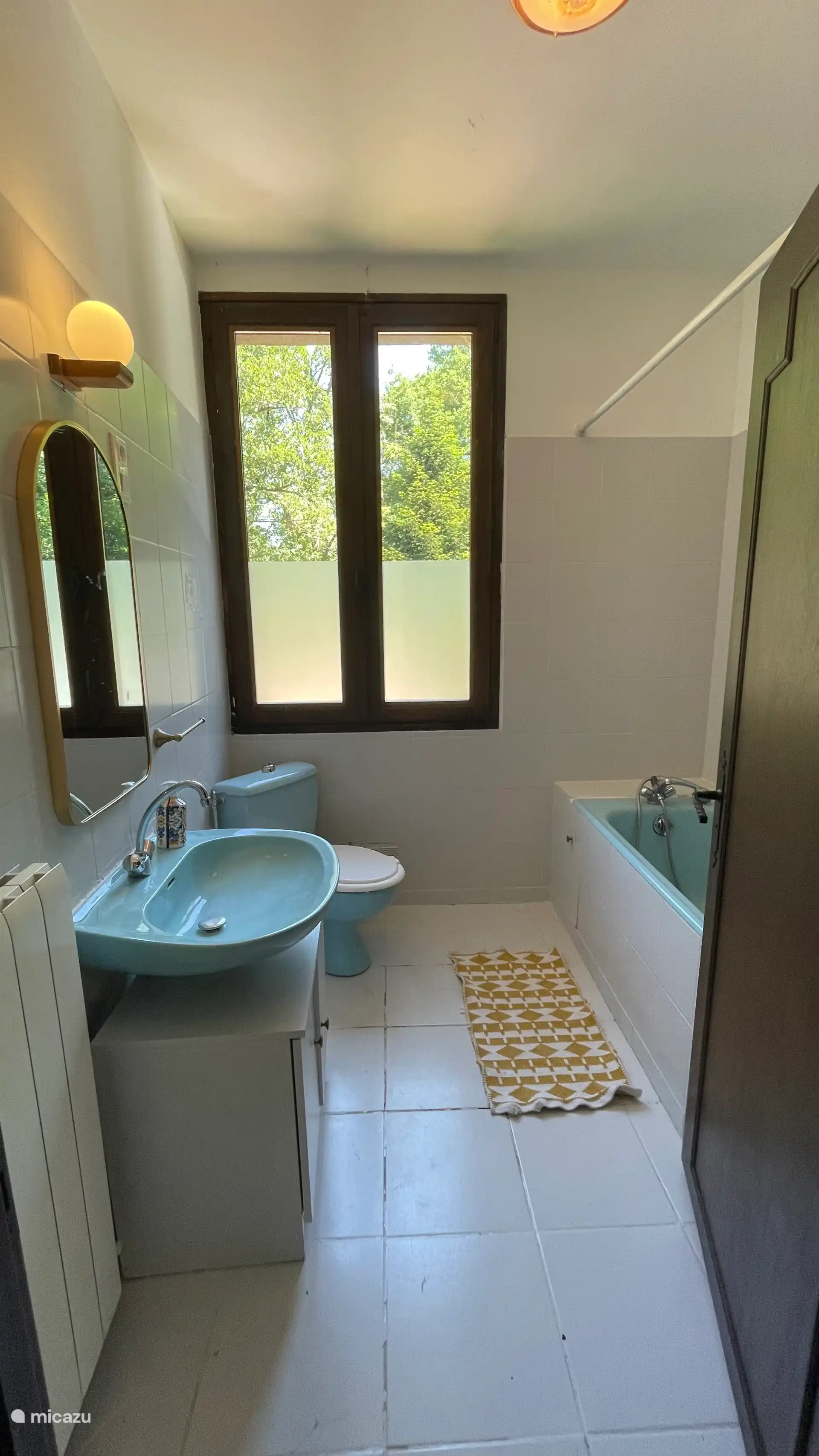 Badkamer met bad, toilet en wastafel