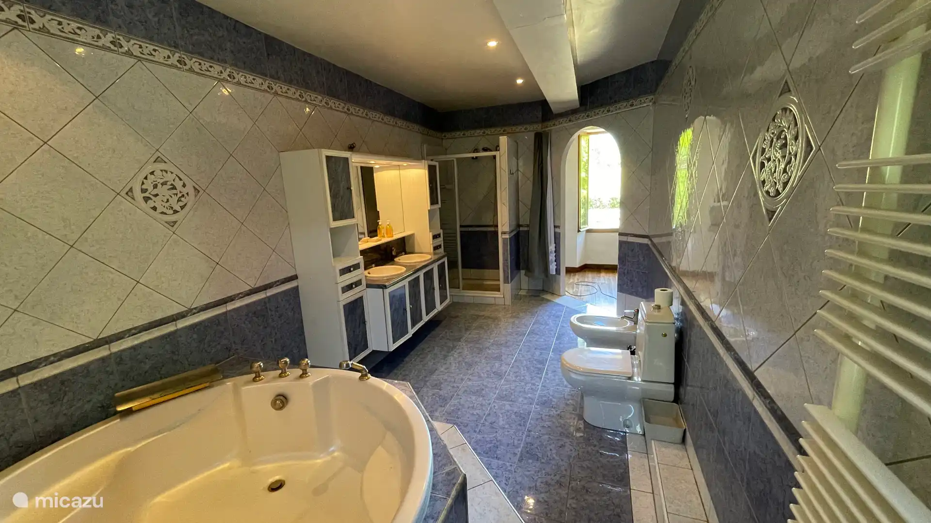 Badkamer met bad, bidet, toilet en waskom