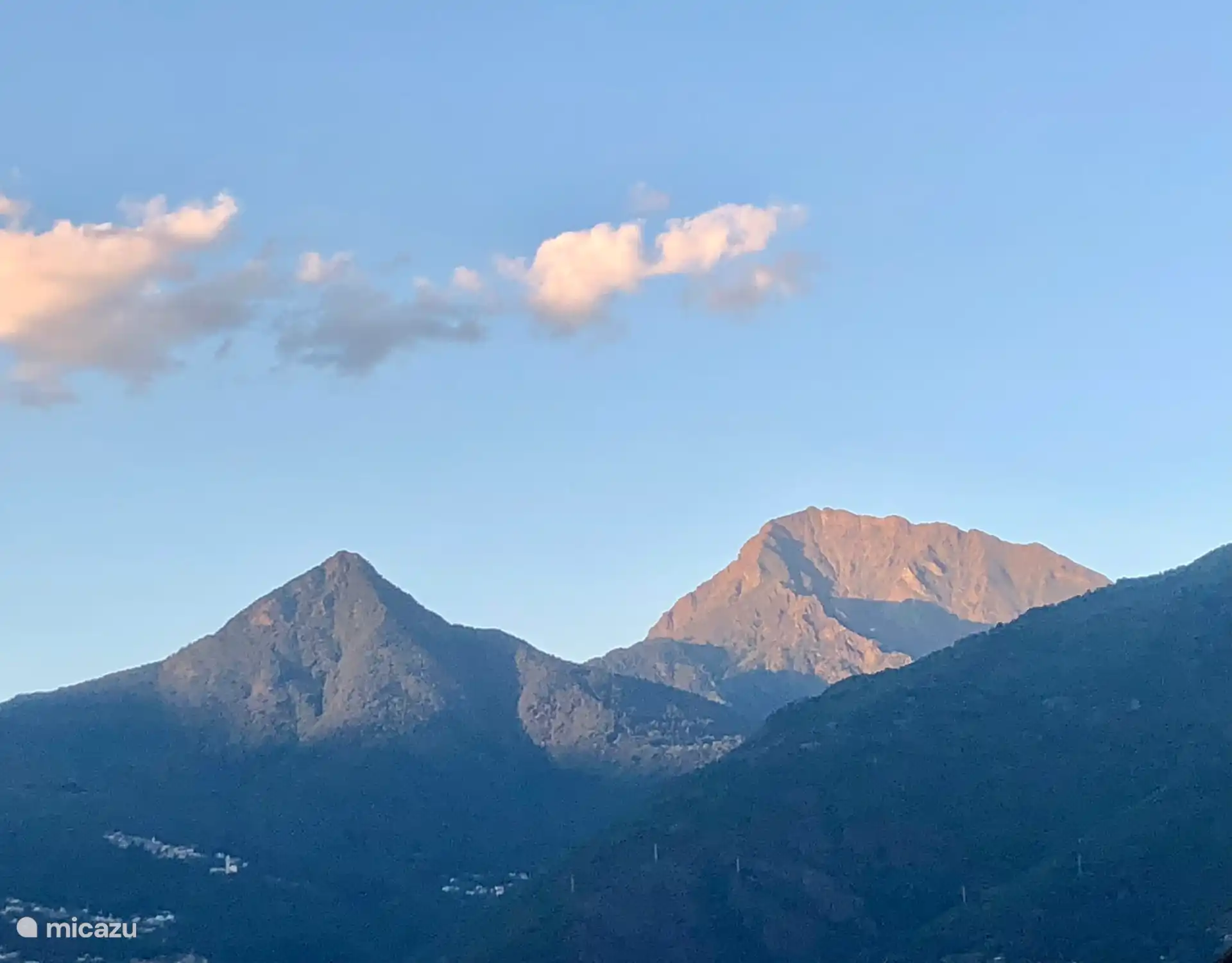 Zicht bergtoppen vanaf woonkamer appartement 
