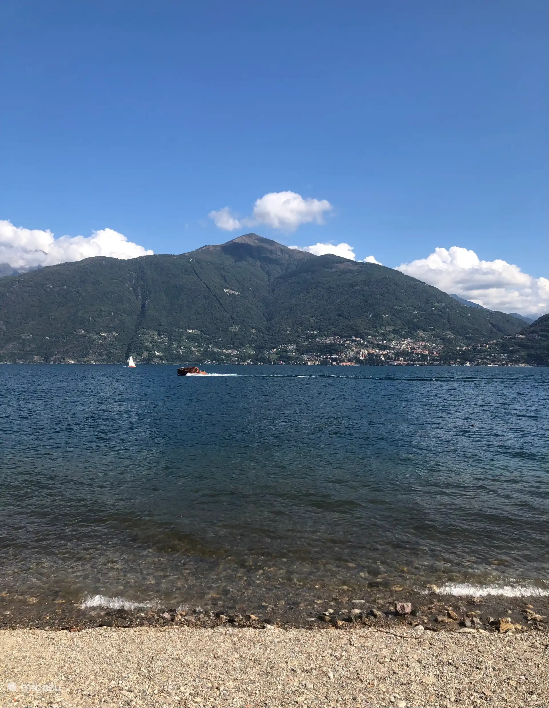 Uitzicht vanuit strand Acquaseria op bergen overzijde meer