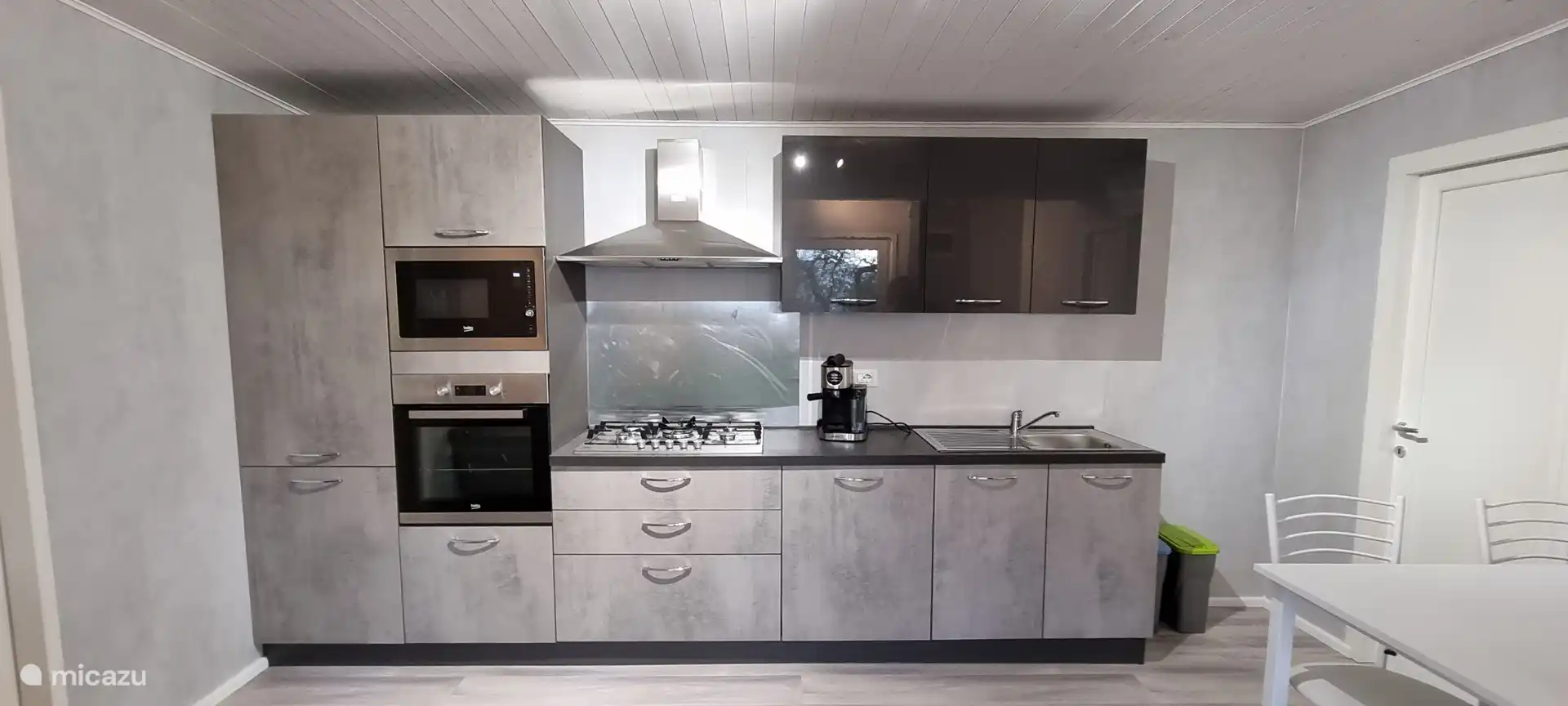 Moderne keuken met gaskookplaat, afzuigkap, koelkast, vriezer, oven, magnetron, vaatwasser, pistonkoffiemachine en waterkoker. Van alle gemakken voorzien.