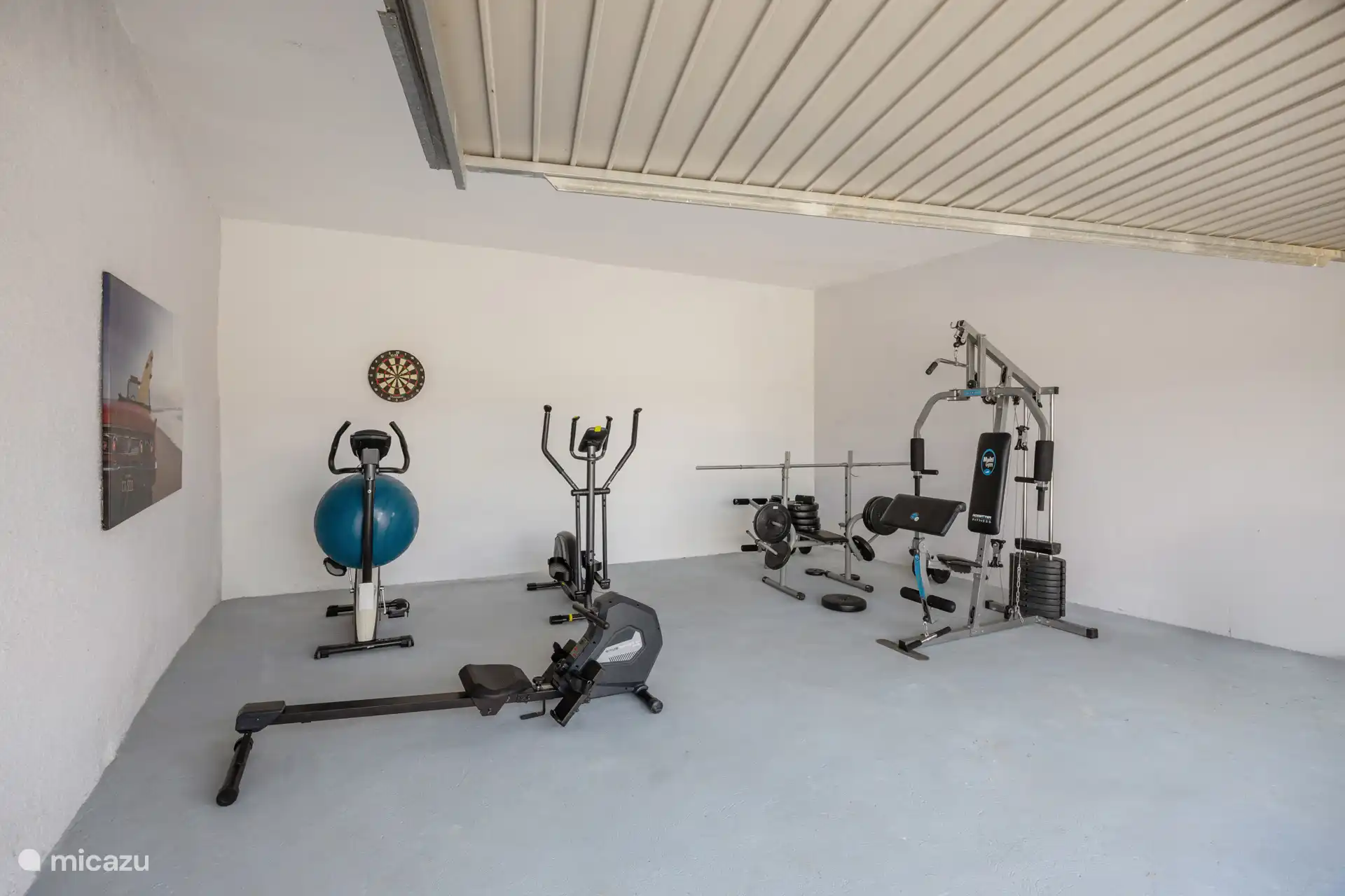 Salle de sport interne avec rameur, elliptique, multi-salle et cible de fléchettes. Pour ceux qui veulent rester actifs même en vacances.