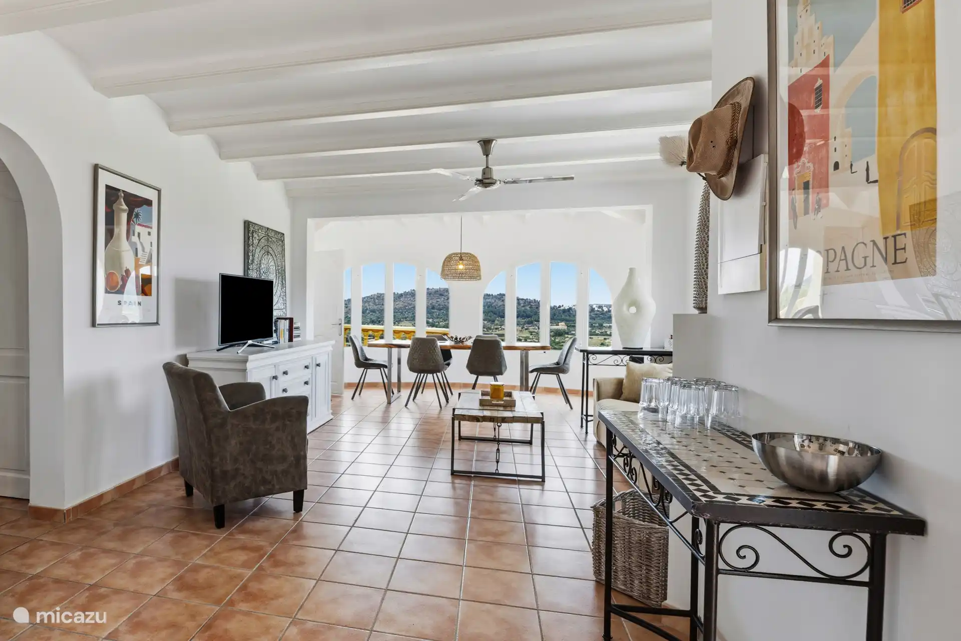 Salon lumineux de l’appartement à l’étage avec des fenêtres en arc, une vue panoramique sur le Montgó et une connexion ouverte à la salle à manger.