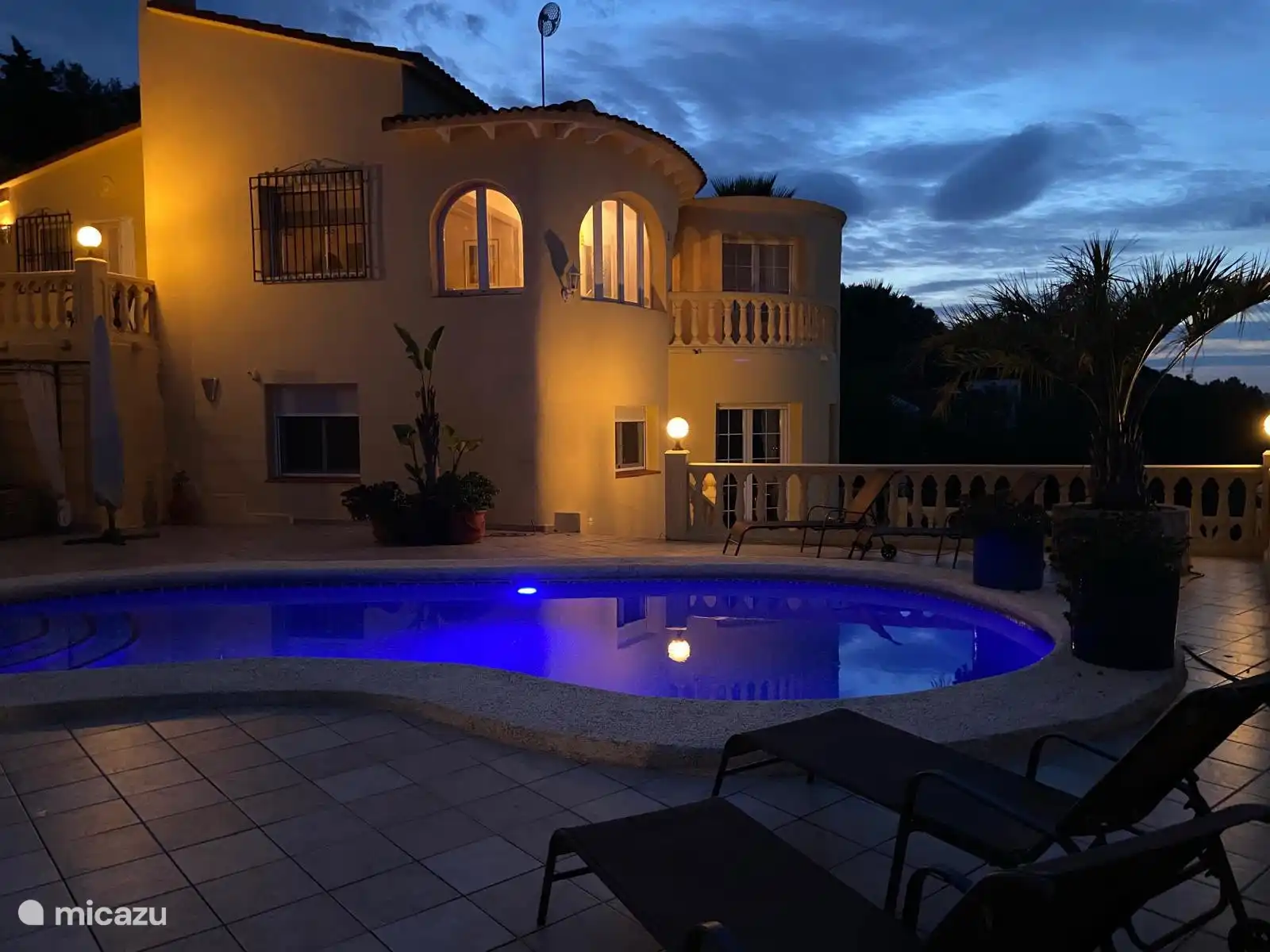 The villa at night, with illuminated windows and the glowing swimming pool – here you will feel right at home