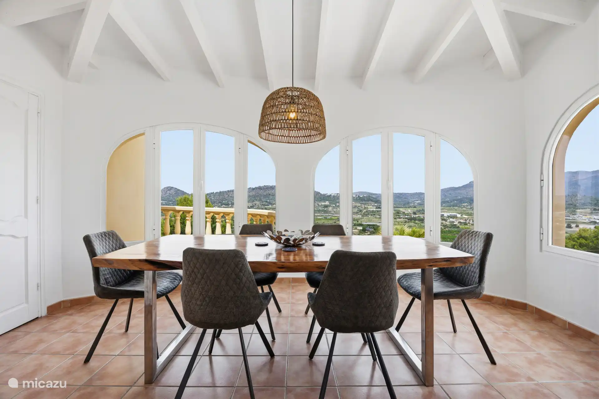 La salle à manger de l’appartement à l’étage à son meilleur — fenêtres voûtées, vue sur le Montgó et espace pour tout le groupe.