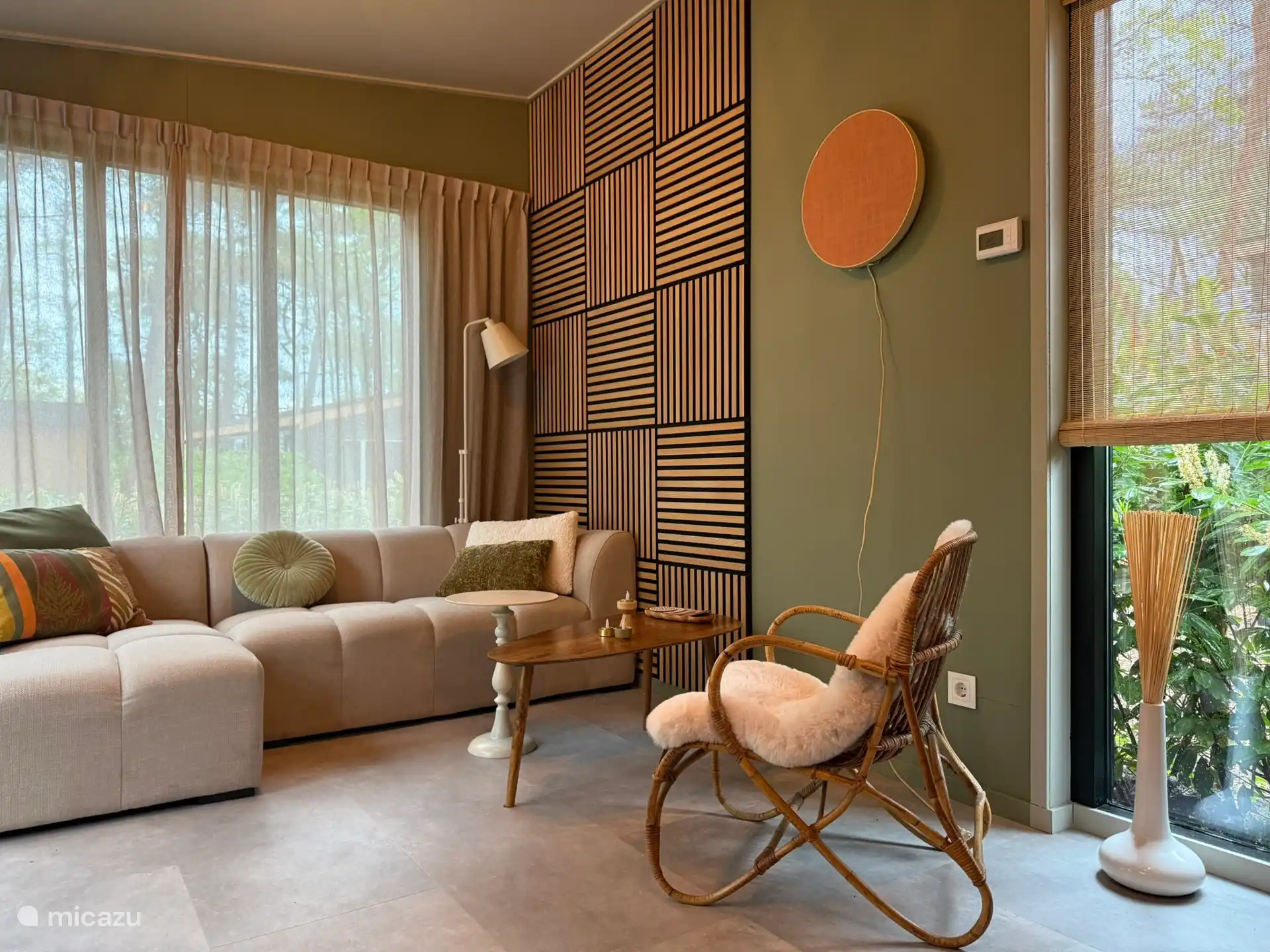 woonkamer met driepersoons loungebank en rotan fauteuil