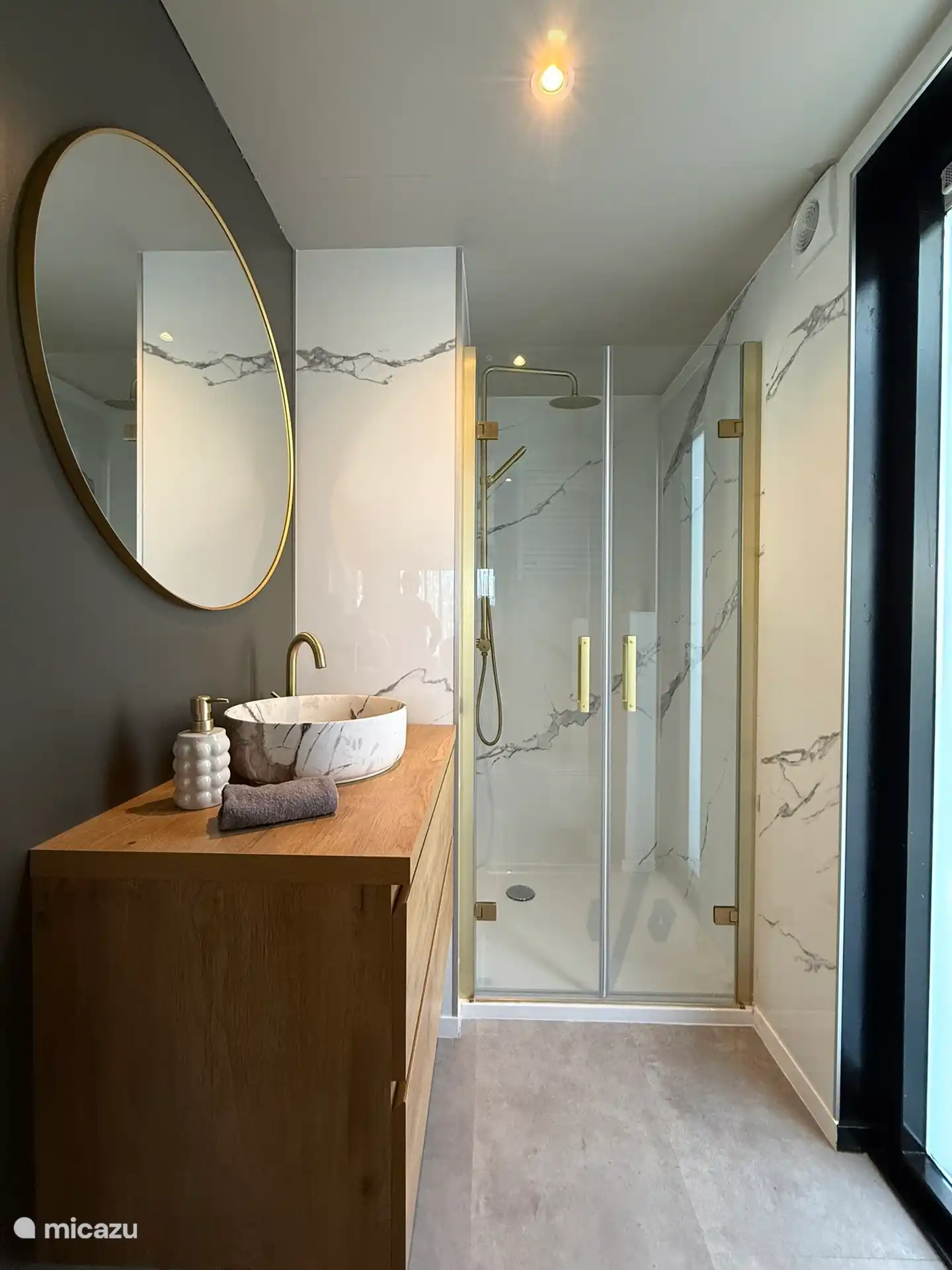 Badkamer met regendouche, wastafelmeubel en toilet