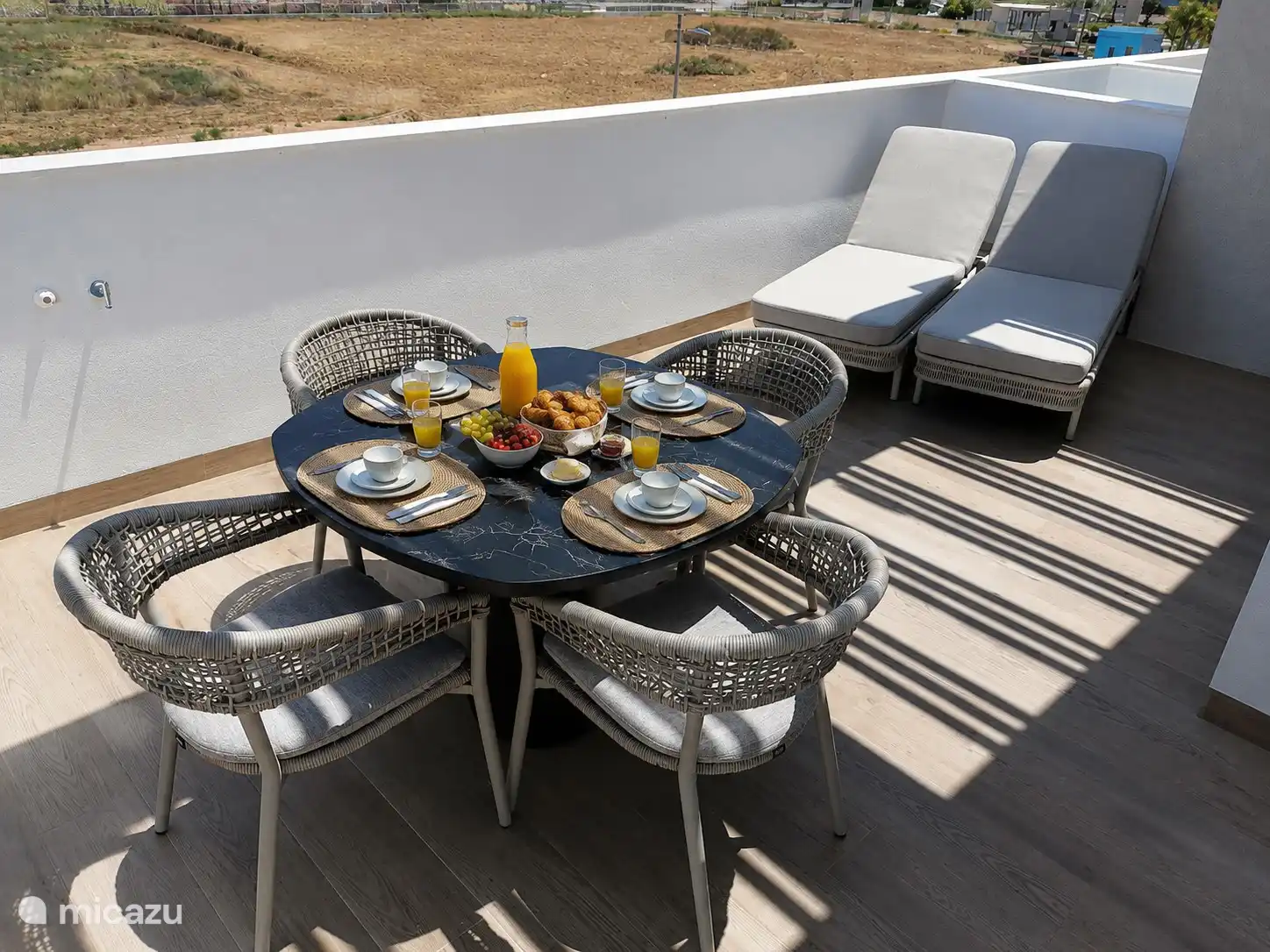Frühstücksterrasse in der Sonne und zwei Sonnenbetten zum Entspannen auf der Terrasse in der Küche