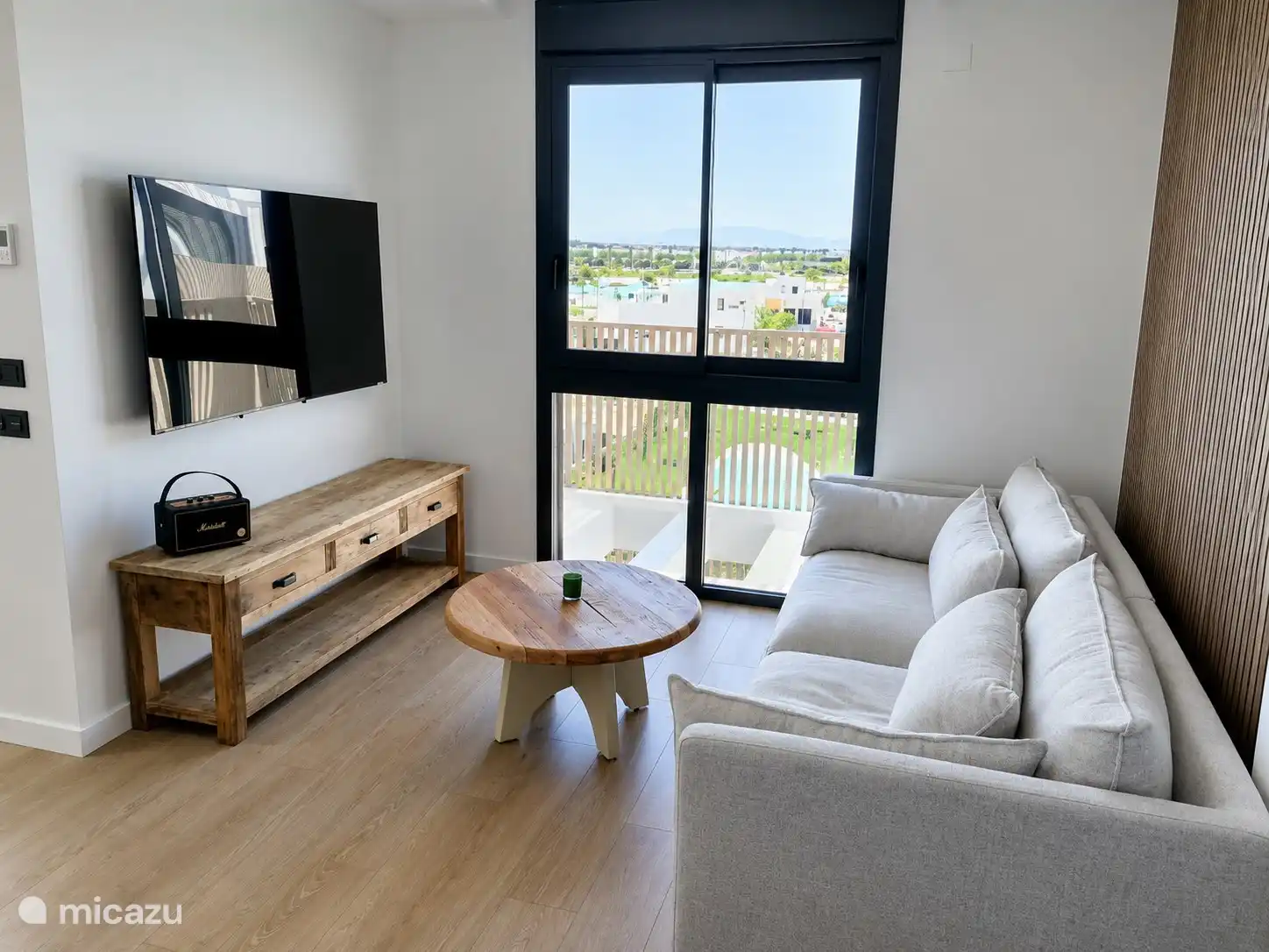 Grande Smart TV pour diffuser et regarder vos émissions préférées sur un canapé style Ibiza 