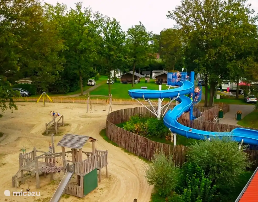 Playing field of the campsite, with next to it the swimming pool with slide.
