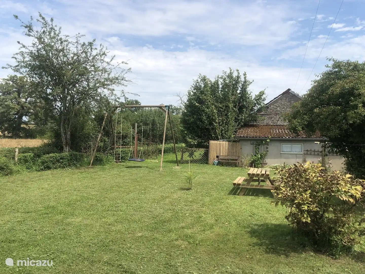 De ruime tuin met achterin onze schuur 