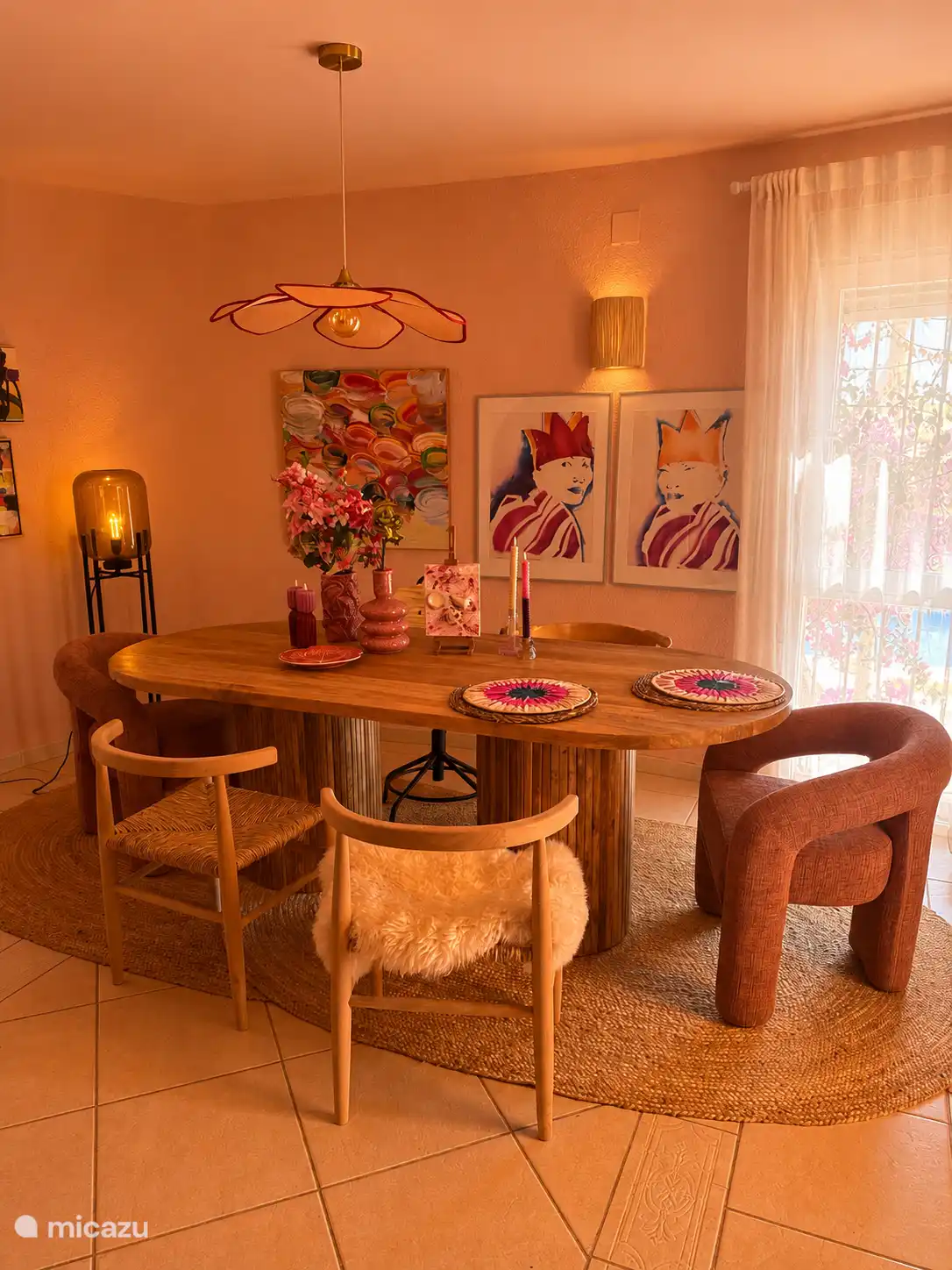 Casa Hibiscus überrascht mit einem künstlerischen Wohnzimmer voller Charakter. Bewundern Sie farbenfrohe Kunstwerke verschiedener Künstler, Designermöbel, warme rosa Wände und eine offene Vitrine mit besonderem Souvenir
