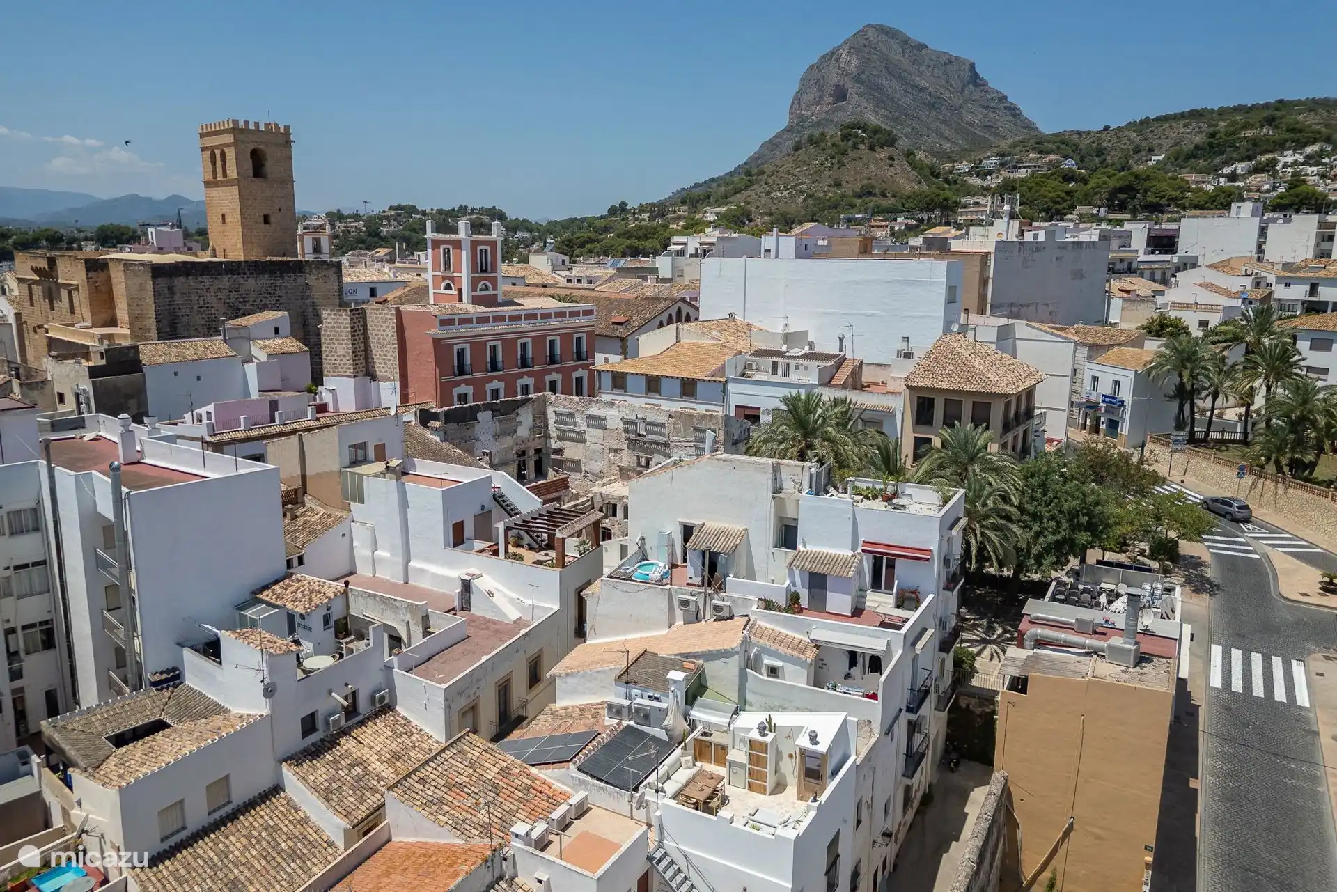Casa Loreto mit Blick auf das stattliche Montgó im Hintergrund und umgeben von der markanten Kirche San Bartolomé und dem alten rosa Sabadell-Bankgebäude