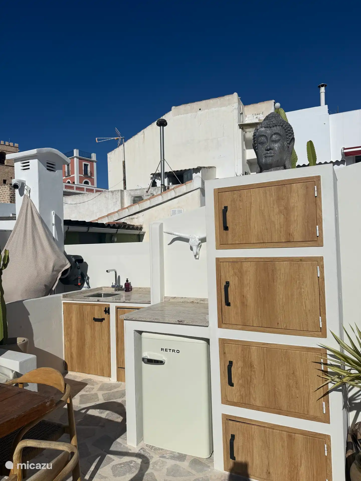 Terrasse sur le toit Casa Loreto, avec vue sur la mer. Avec cuisine extérieure, douche, salle à manger, chaises longues, parasols.