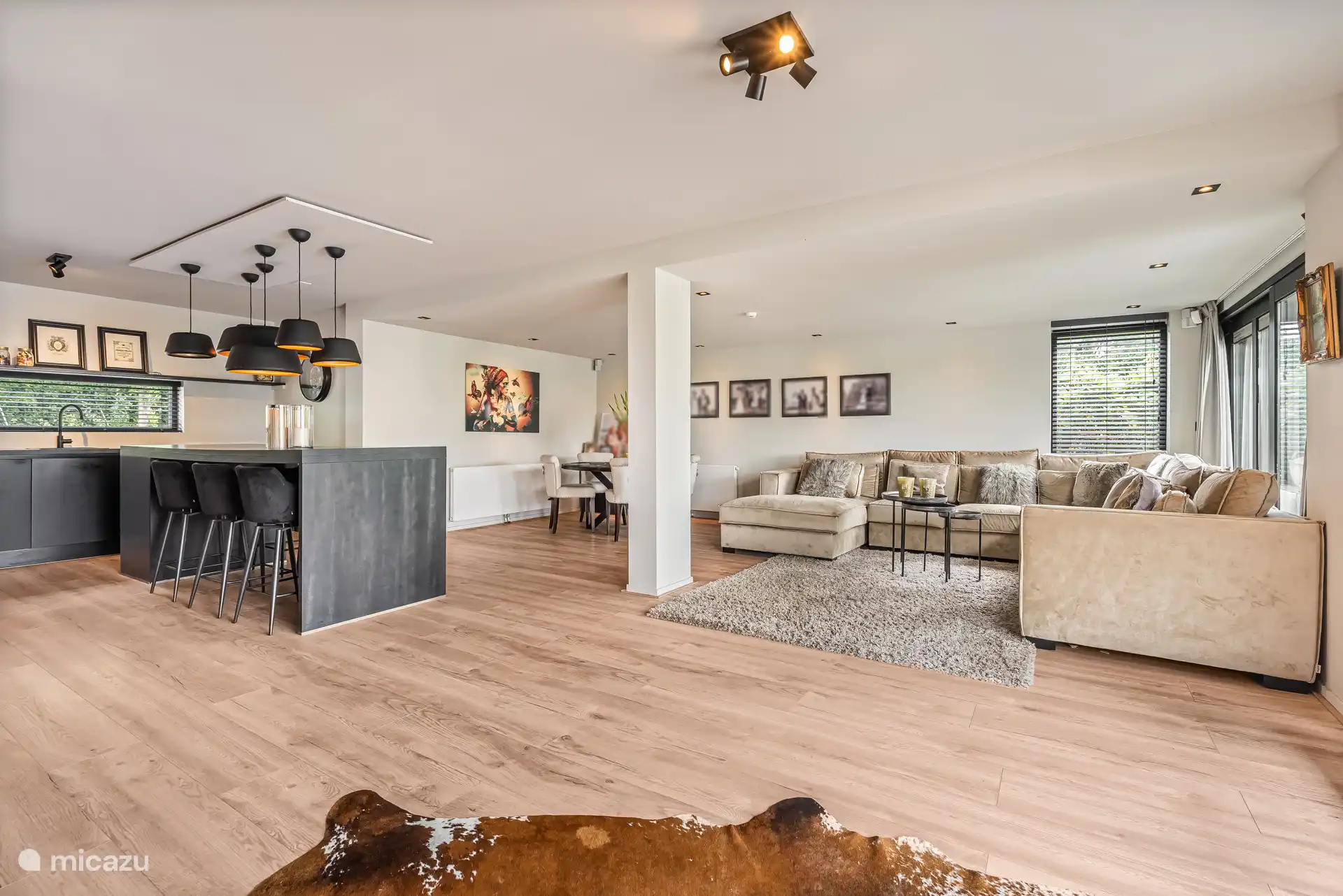 Bright and spacious living room with open kitchen and cozy sitting area.